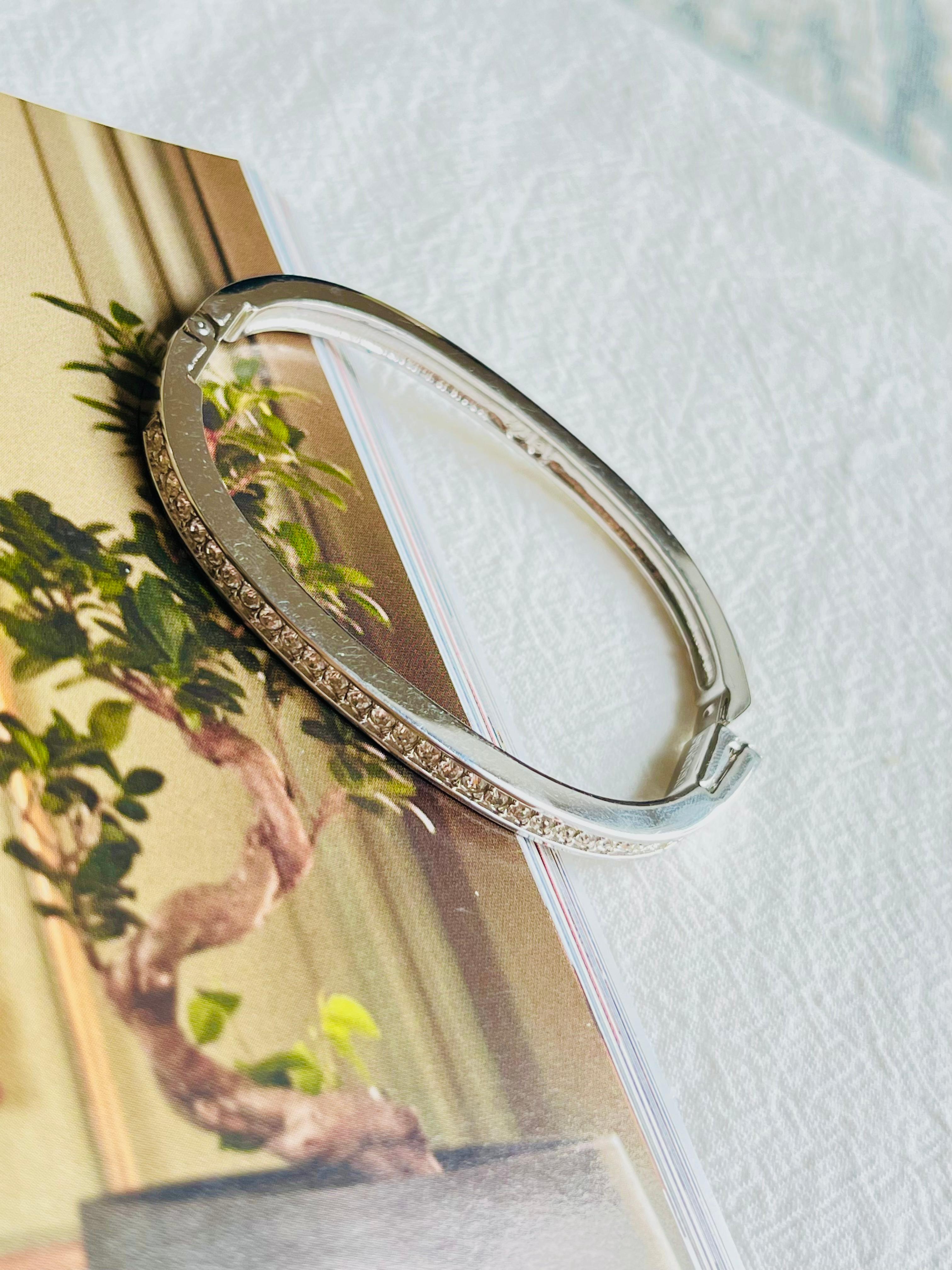 Very good condition. With light surface wear. 100% genuine.

This attractive and stylish bangle by Swarovski is an essential addition to any jewellery collection. It is beautifully embellished with a line of clear crystal pavé that adds brilliant