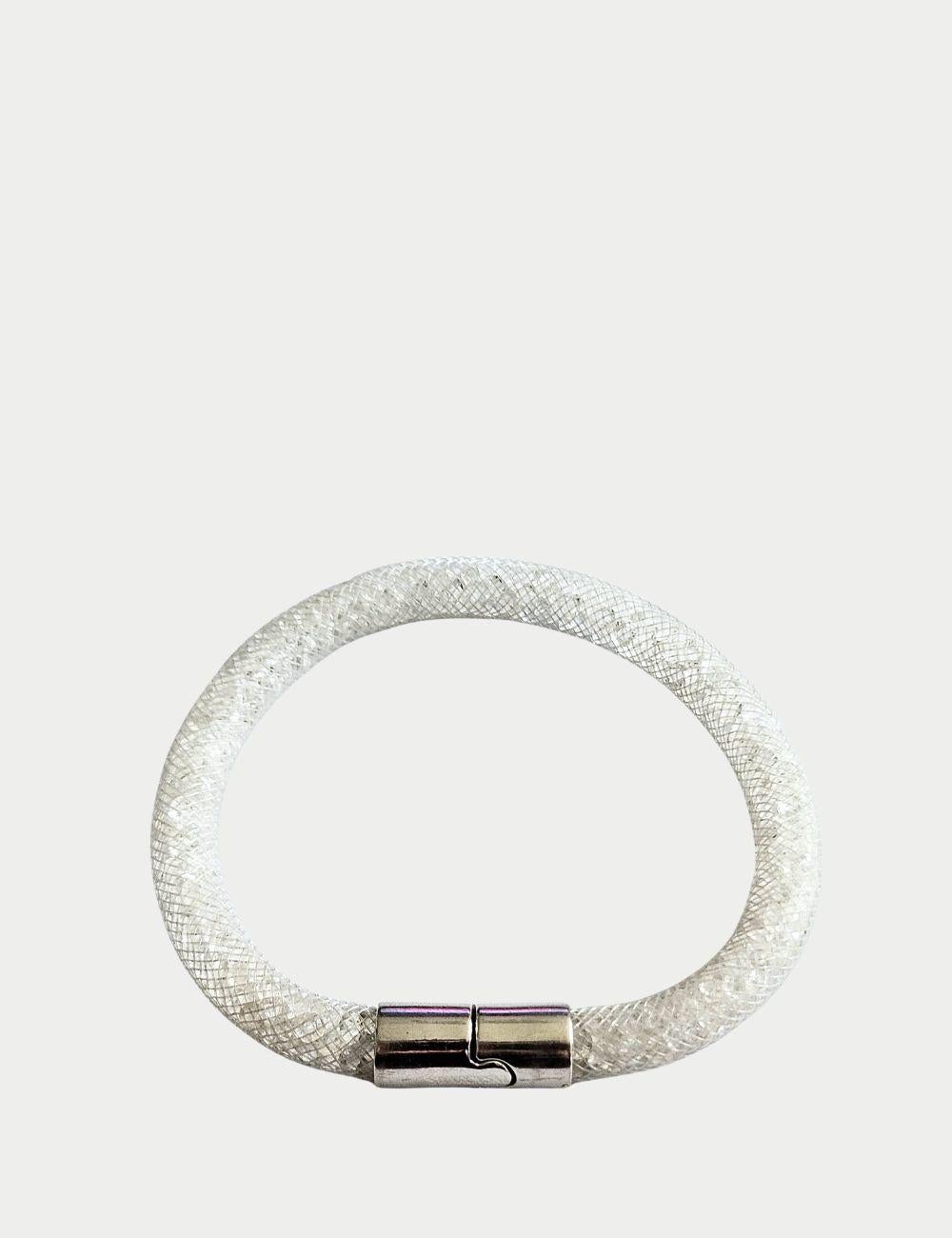 Brilla di un'eleganza senza tempo con questo braccialetto di cristalli bianchi Swarovski, realizzato con un tubo a maglie flessibili riempito di abbaglianti cristalli Swarovski. Il suo luminoso scintillio bianco lo rende un accessorio versatile, che