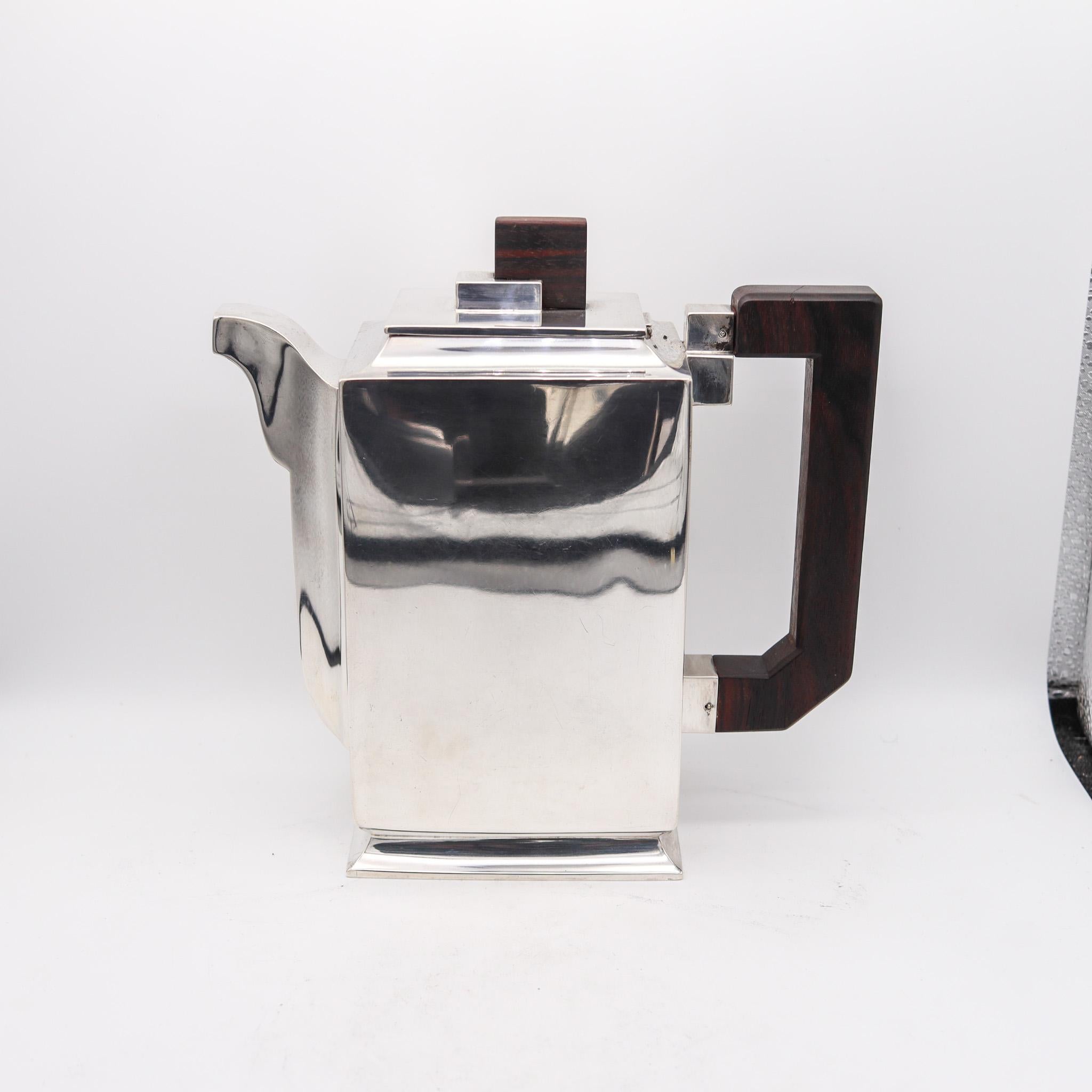 An art deco coffee set in silver and Ebony.

This rare model is of a very high quality execution, reflecting the full epitome of Art Deco spirit and the geometric art design of the time as use of rich materials like Macassar ebony and silver.