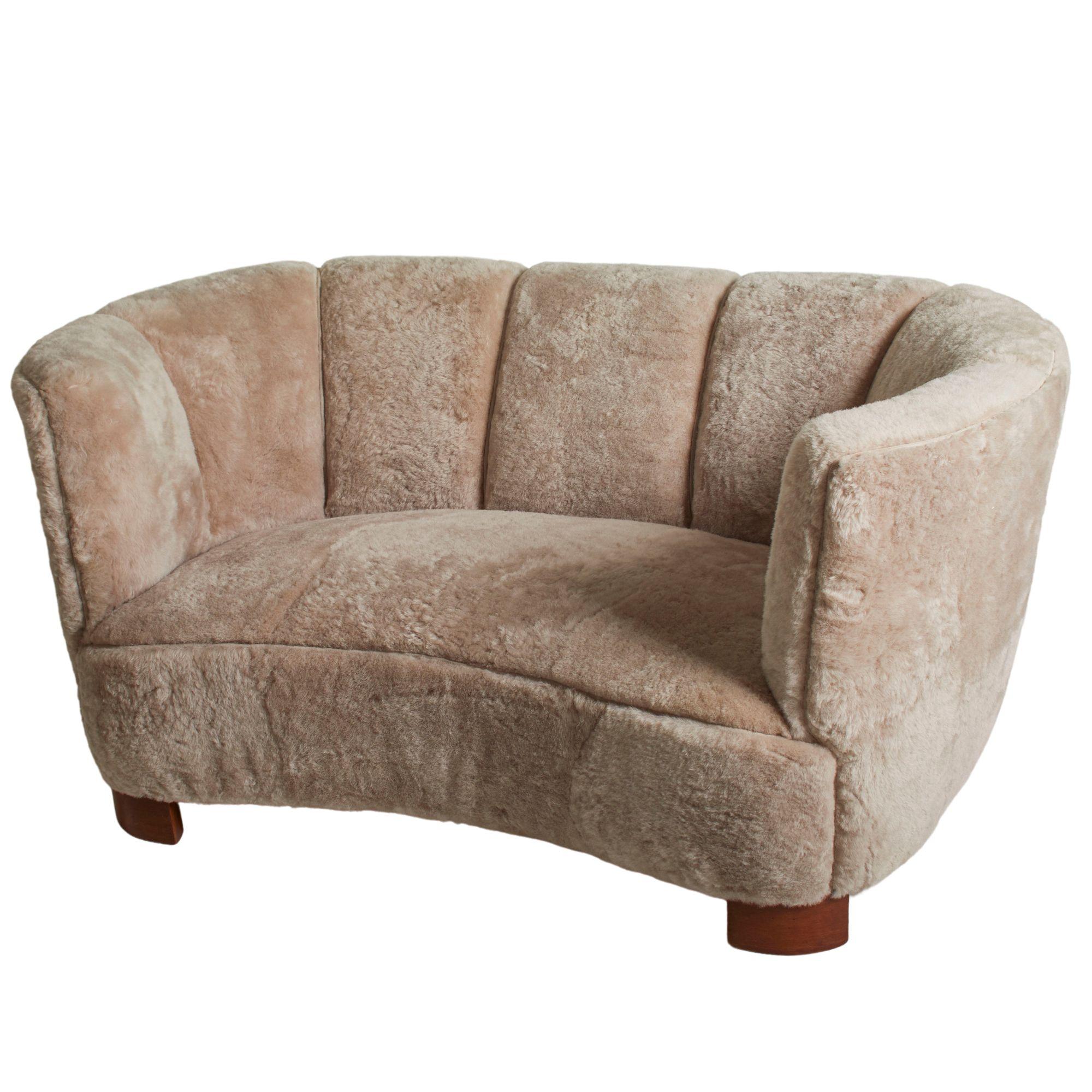 Sweden 1950's rounded loveseat with sheared shearling and suede piping.