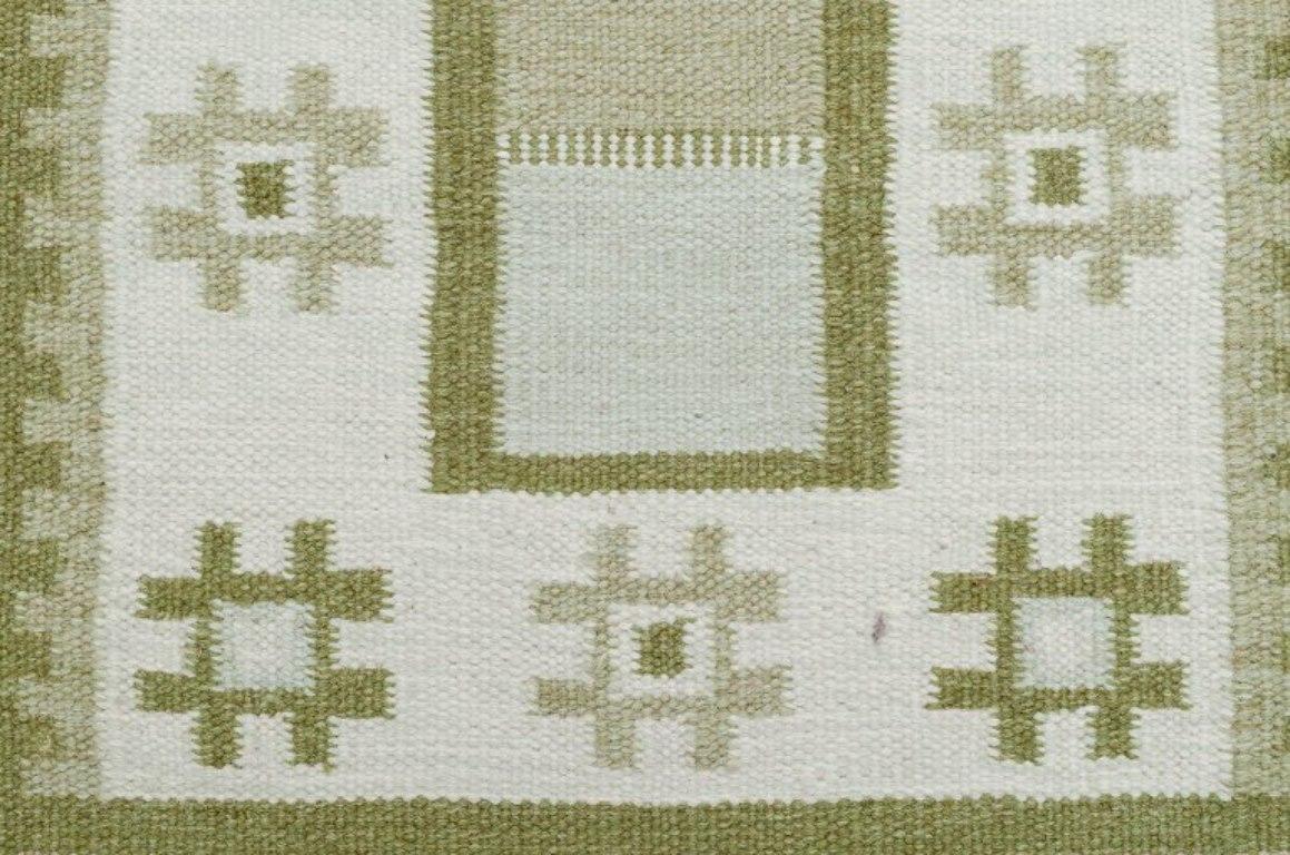 Suédois Tapis en laine de Suède selon la technique Rölakan. Couleurs vertes sur fond blanc. en vente