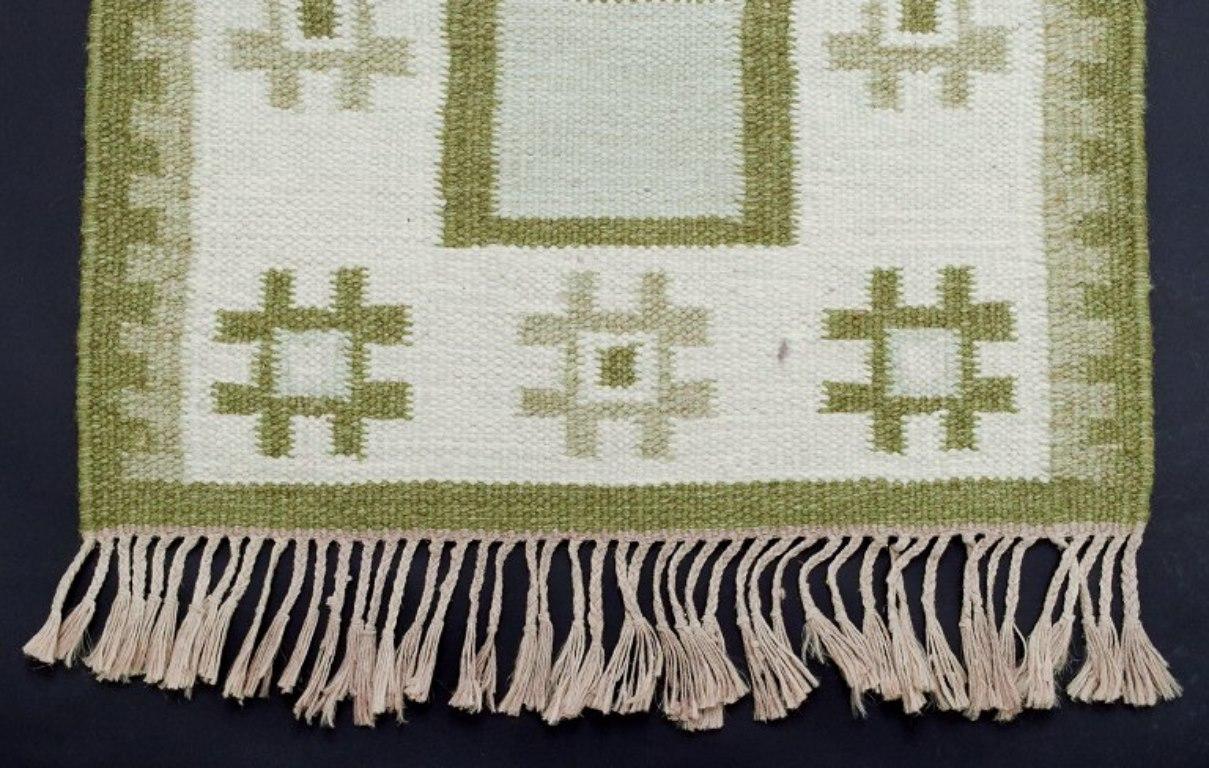 Hand-Woven Sweden wool carpet in Rölakan technique. Green colors on a white background. For Sale