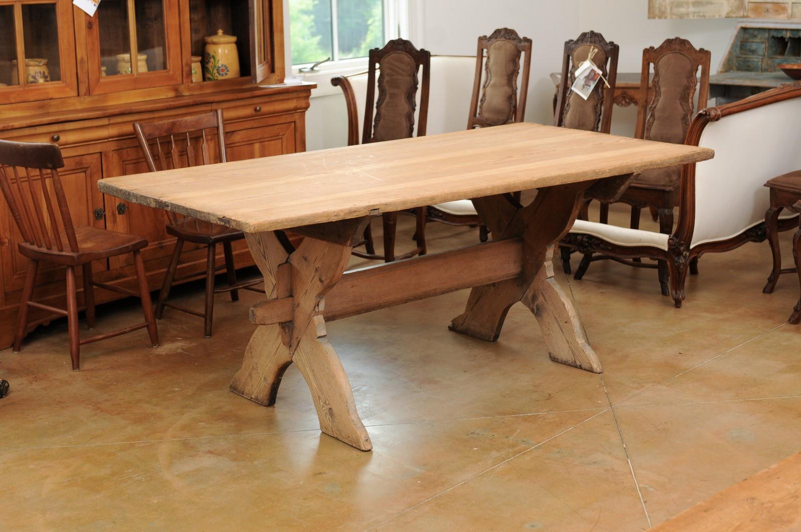 A Swedish sawbuck trestle farm table from the mid 18th century, with X-Form base, natural finish and nice patina. Created in Sweden during the third quarter of the 18th century, this farm table features a rectangular top sitting above a double