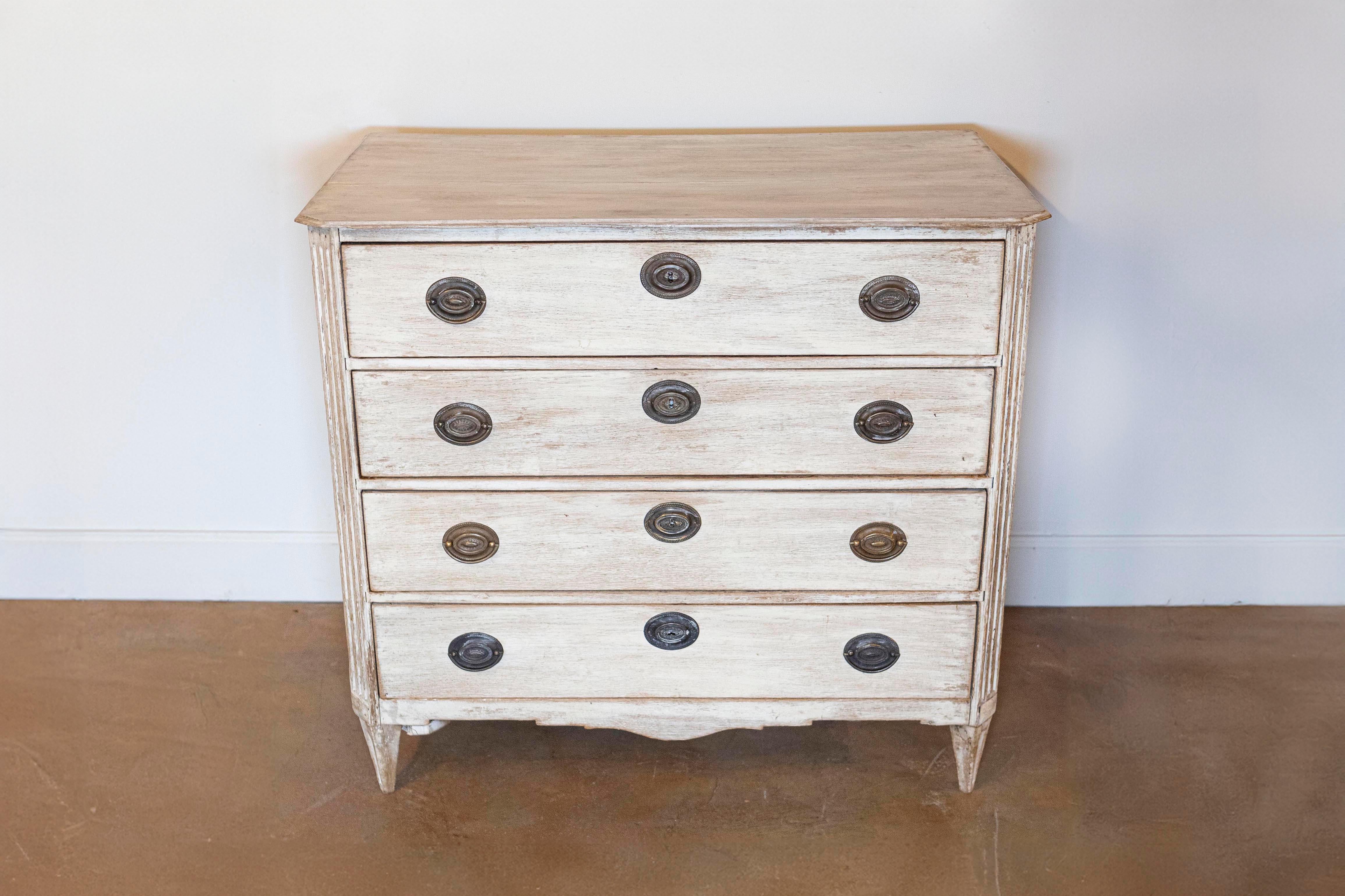 A Swedish period Gustavian four-drawer commode from the late 18th century with its old hardware. This Swedish chest circa 1780 features a rectangular top with chamfered sides in the front. Each drawer is adorned with oval escutcheons and handles. In