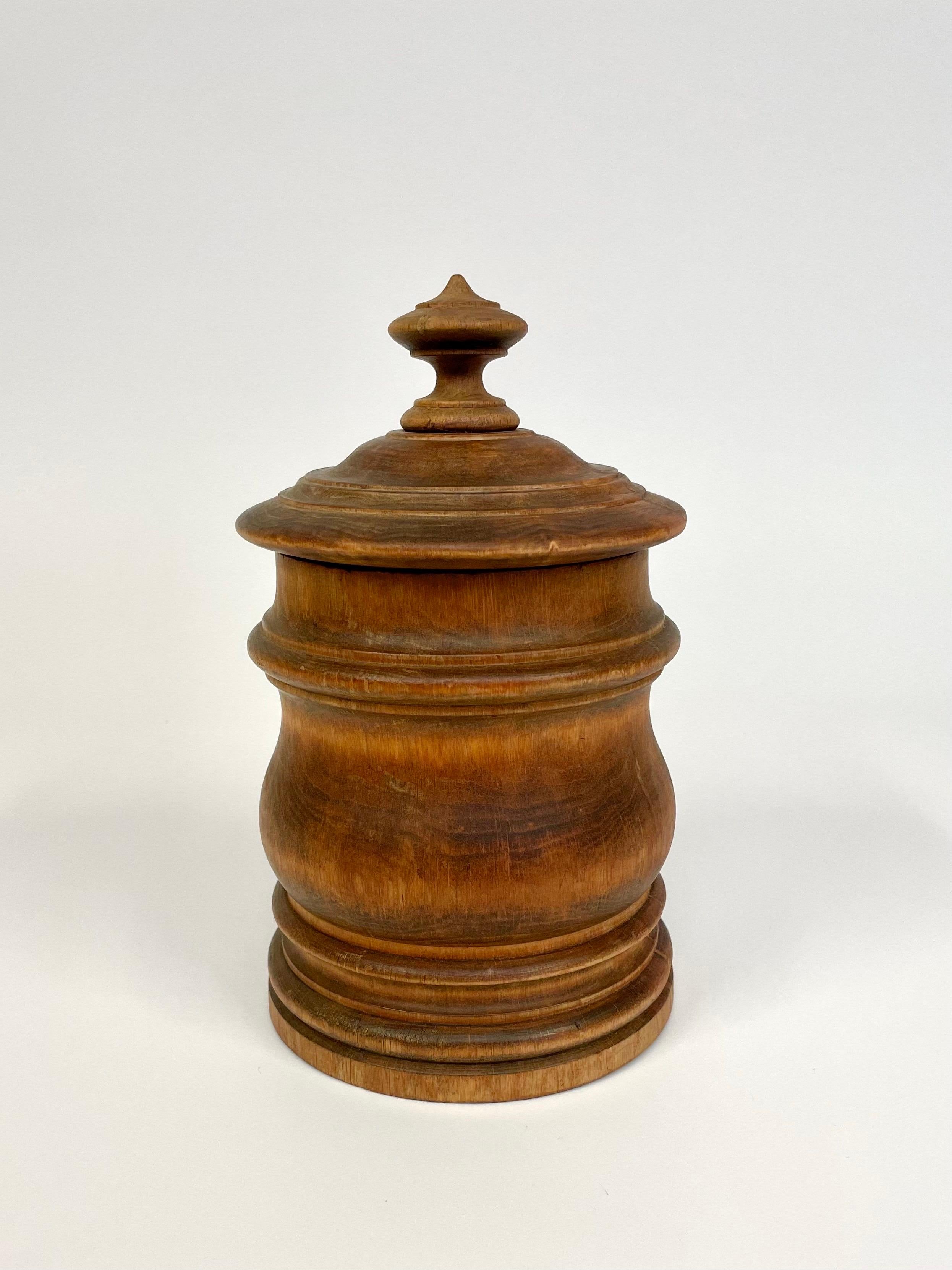 Il s'agit d'une boîte à tabac suédoise de la fin du 19e siècle en bois tourné et avec un couvercle tourné bien ajusté. 
Il se présente dans une teinte légèrement brique et il reste dans la boîte un léger et agréable parfum de tabac.
