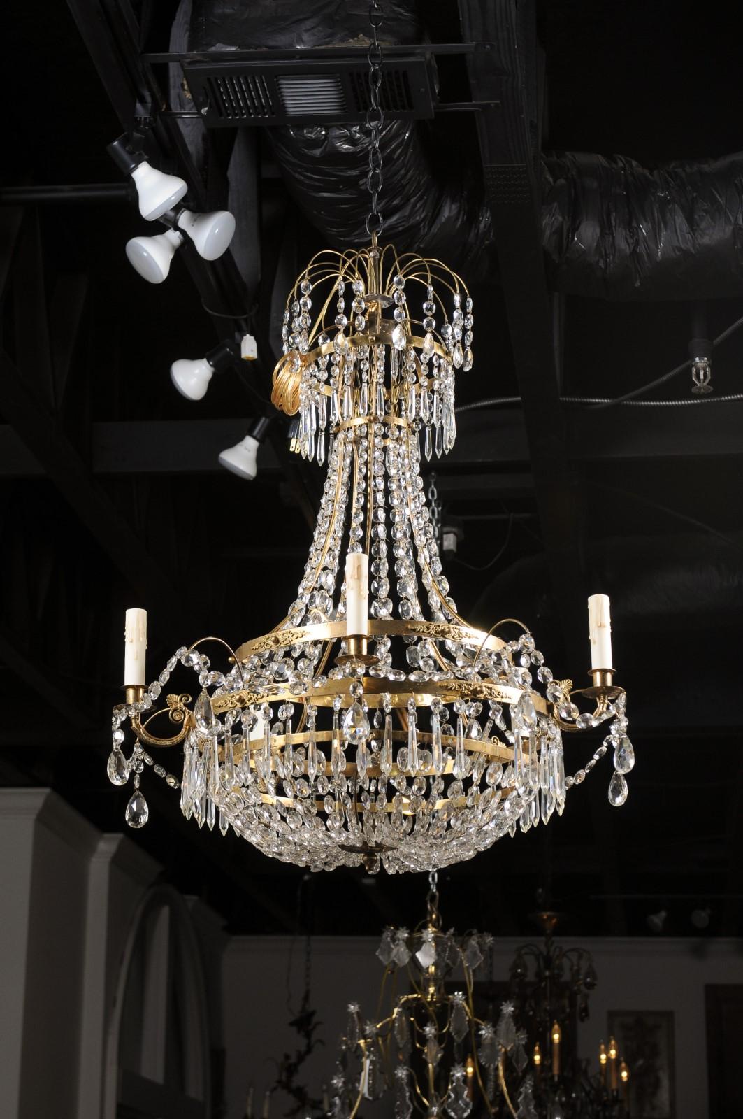 A Swedish Gustavian period five-light crystal chandelier from the early 19th century, with brass armature, spear crystals and floral motifs. Created in Sweden during the first decade of the 19th century, this Gustavian crystal basket chandelier