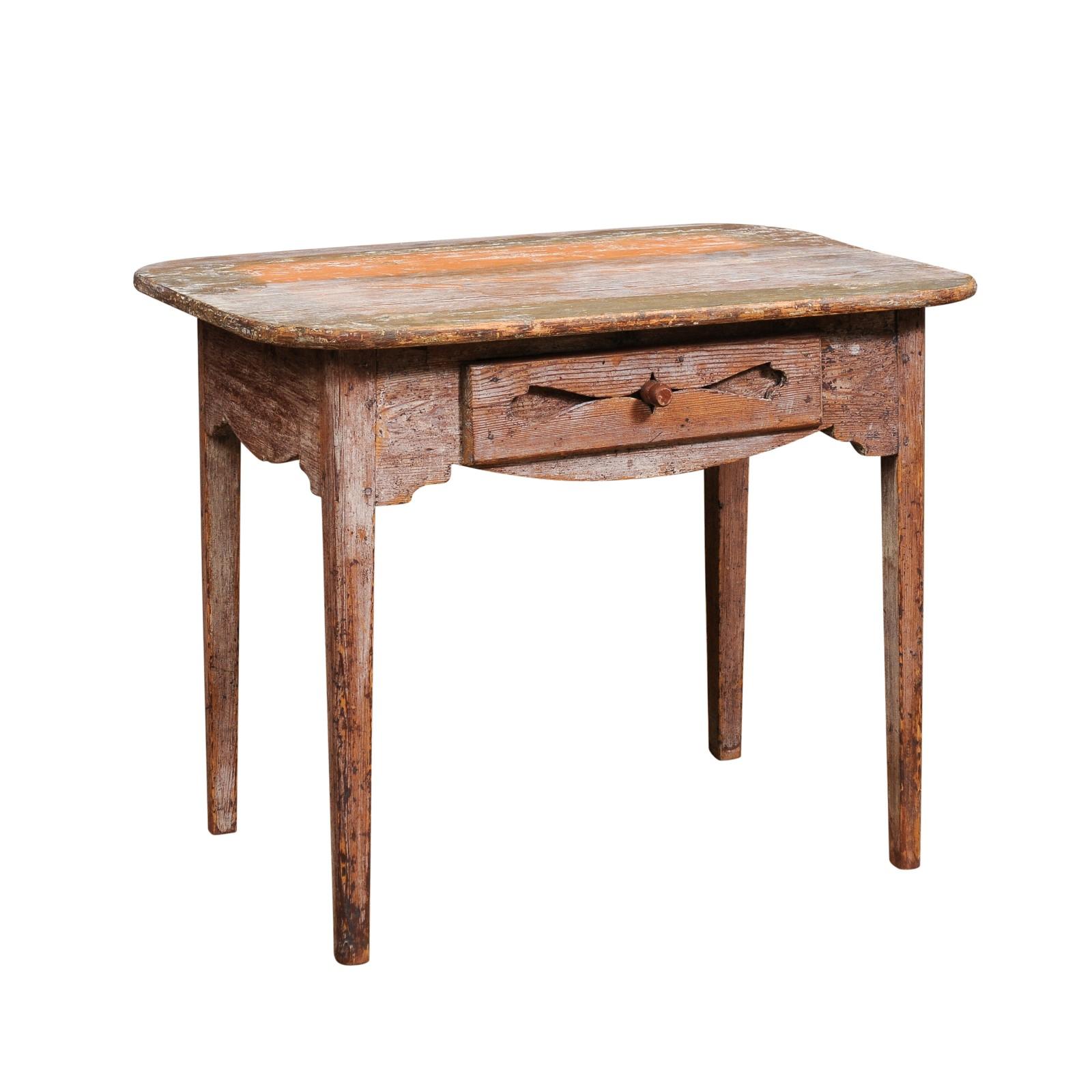 A Swedish side table from circa 1820, with half stripped look, single drawer, tapered legs and weathered appearance. This Swedish side table from circa 1820 exudes rustic charm and authenticity. It has been meticulously scraped back to its original