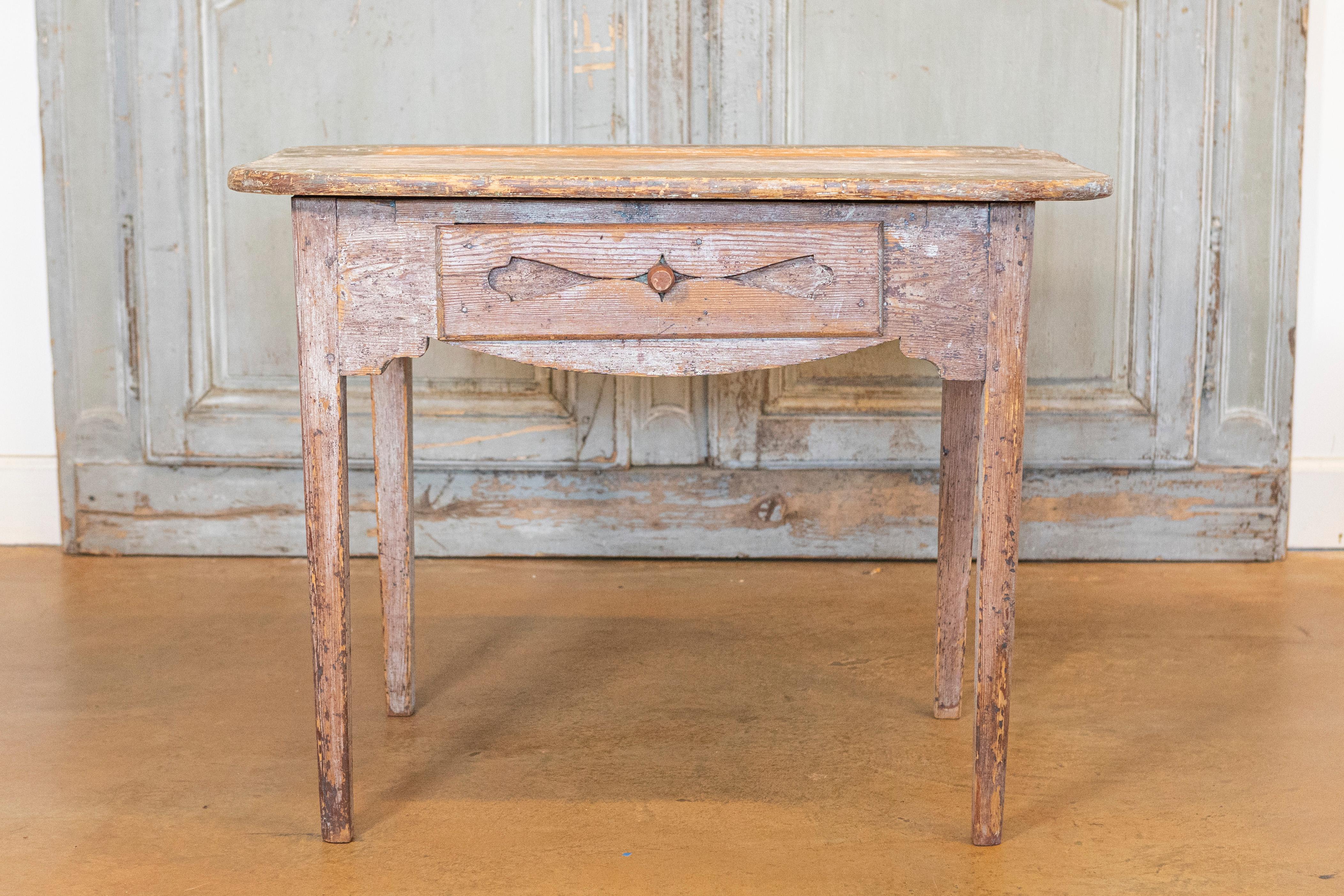 Table d'appoint suédoise datant d'environ 1820, avec un aspect à moitié dépouillé, un seul tiroir, des pieds effilés et un aspect altéré. Cette table d'appoint suédoise datant d'environ 1820 respire le charme rustique et l'authenticité. Il a été