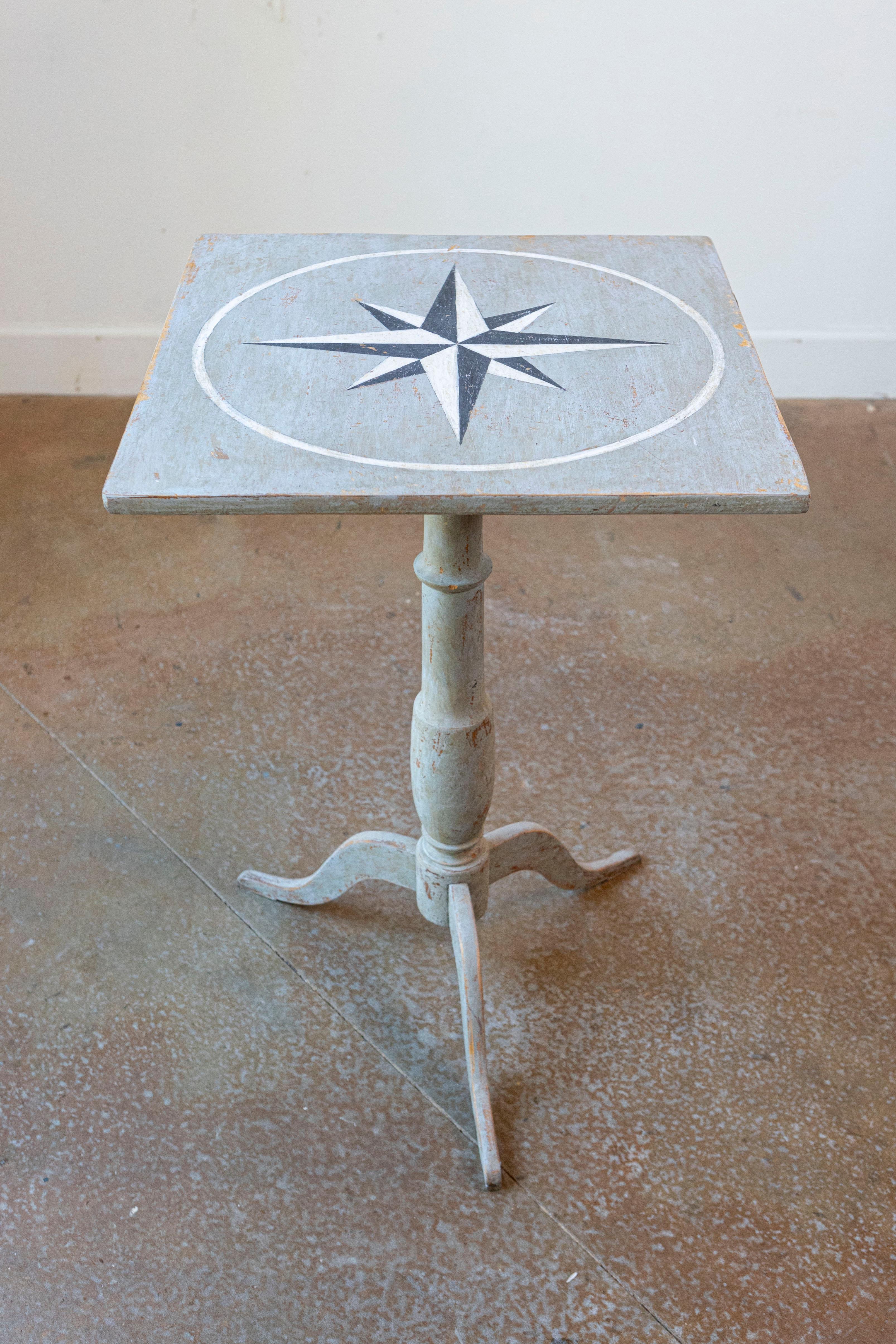 Table d'appoint suédoise en guéridon peint en gris, avec base à piédestal et motifs étoilés, du milieu du 19e siècle. Cette table d'appoint peinte en suédois présente un plateau presque carré, orné d'un exquis motif de rose des vents. Ce plateau est