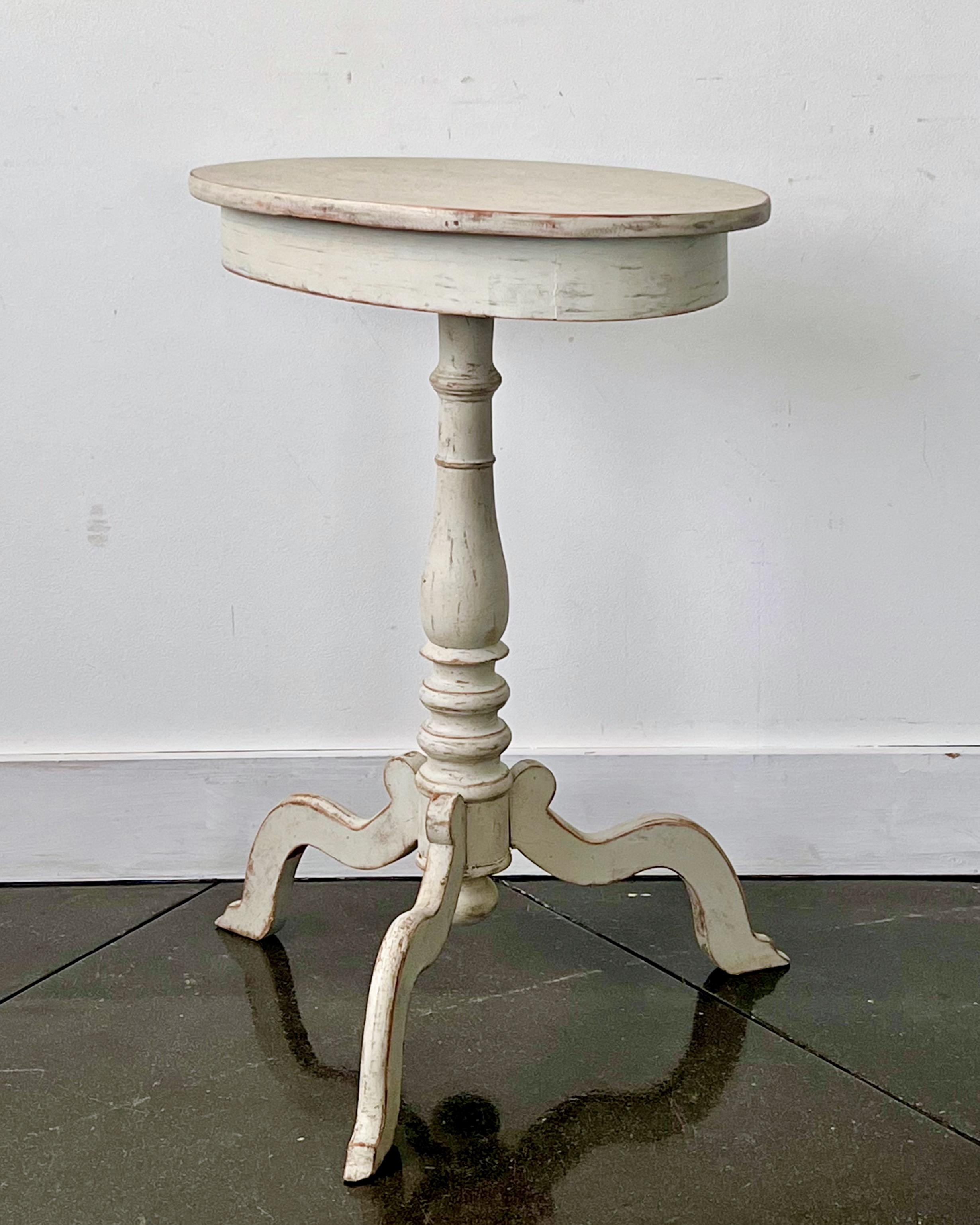 Charming Swedish 1850s painted oval top with wide apron, turned pedestal on elegant carved tripod leg base.
