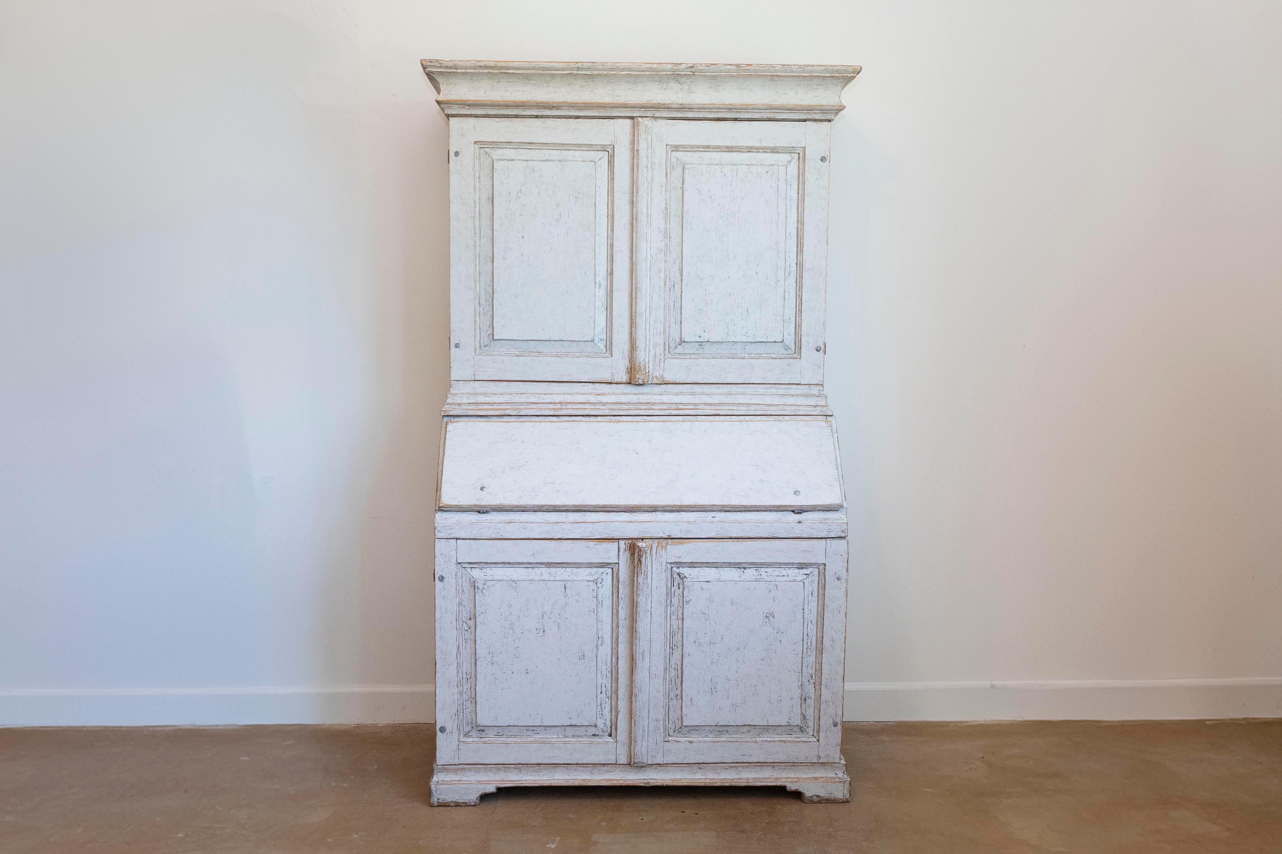 Swedish 19th century two-part painted wood secretary circa 1856 with slant front desk, four doors and bracket feet. of Scandinavian taste for light palettes. Enrich your space with a touch of Swedish charm, showcased in this two-part secretary,