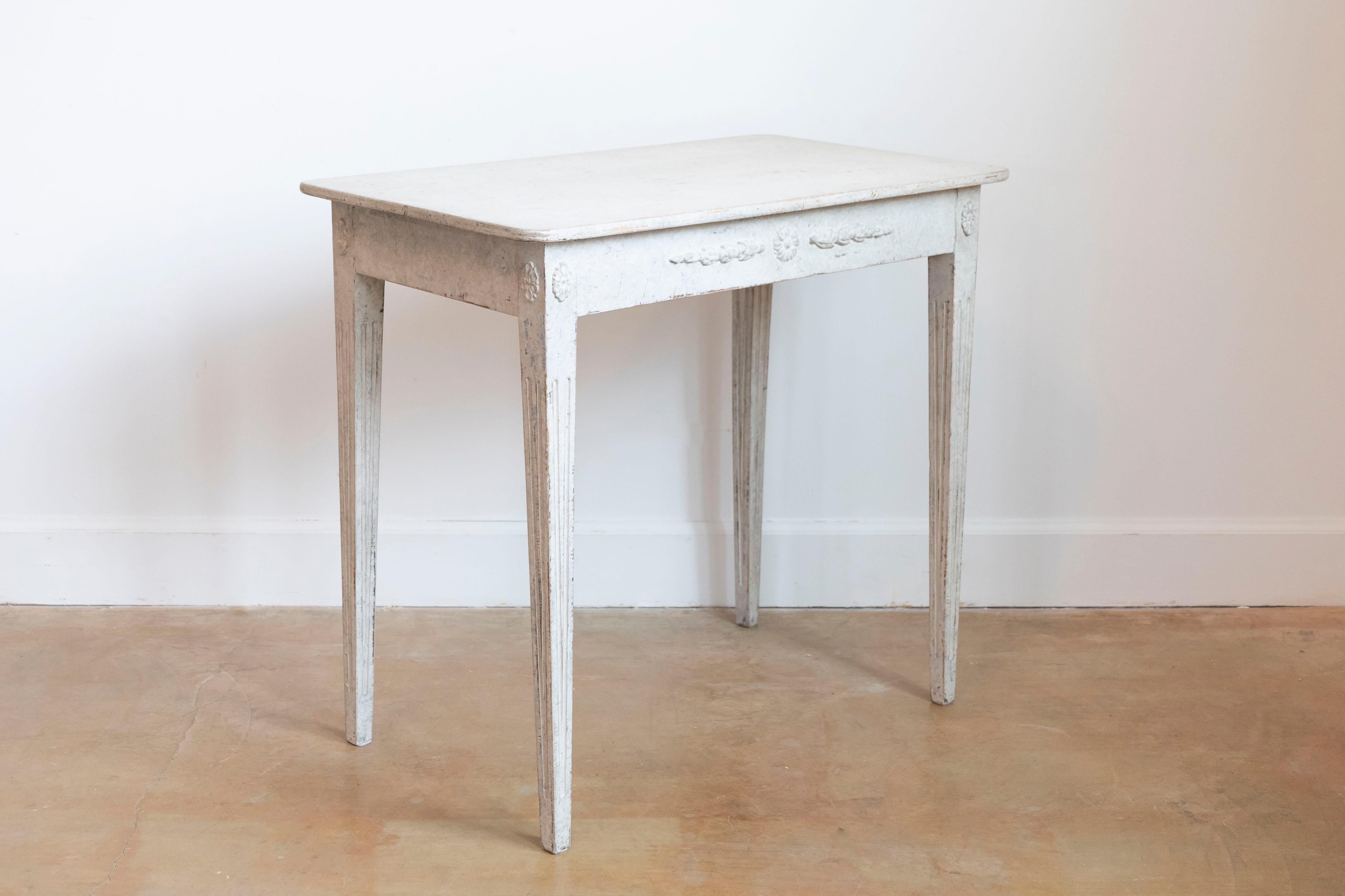 Console suédoise en bois peint de style gustavien du milieu du XIXe siècle, avec tablier sculpté, rosettes et pieds fuselés cannelés. Créée en Suède au cours du troisième quart du XIXe siècle, cette table console présente les caractéristiques