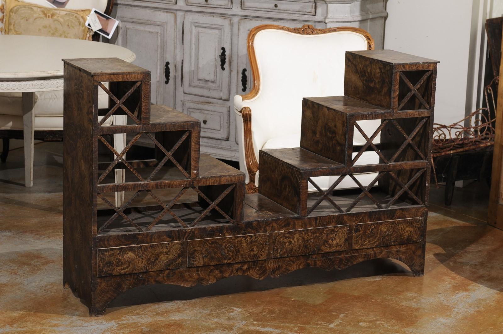 A Swedish stepped flower stand from the mid-19th century, with drawers and cross motifs. Created in Sweden during the third quarter of the 19th century, this flower stand attracts our attention with its burl style finish and stepped structure.