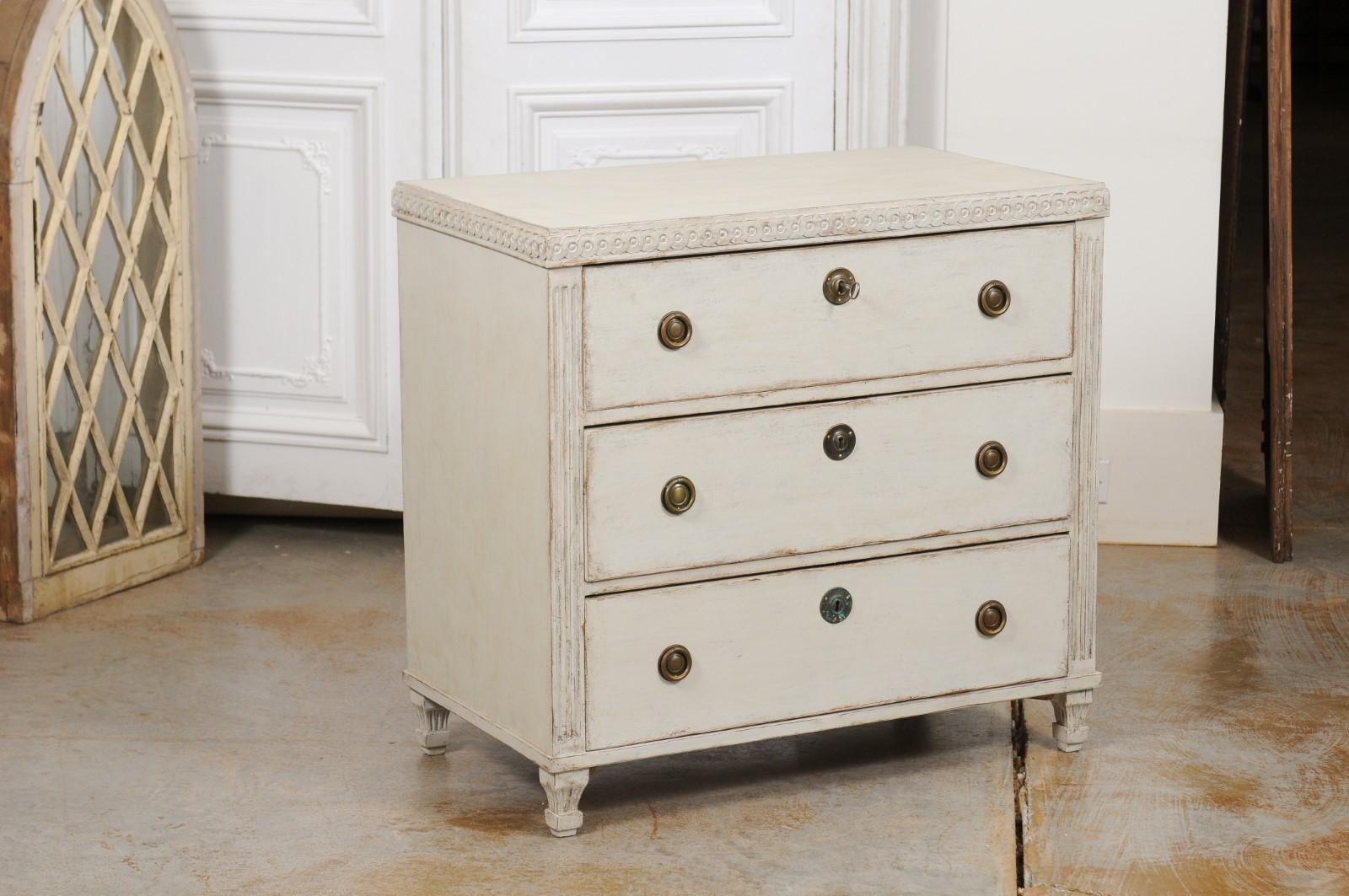 A Swedish neoclassical style painted wood chest of drawers from the mid-19th century, with guilloche motifs and fluted side posts. Created in Sweden during the third quarter of the 19th century, this painted chest features a rectangular top sitting