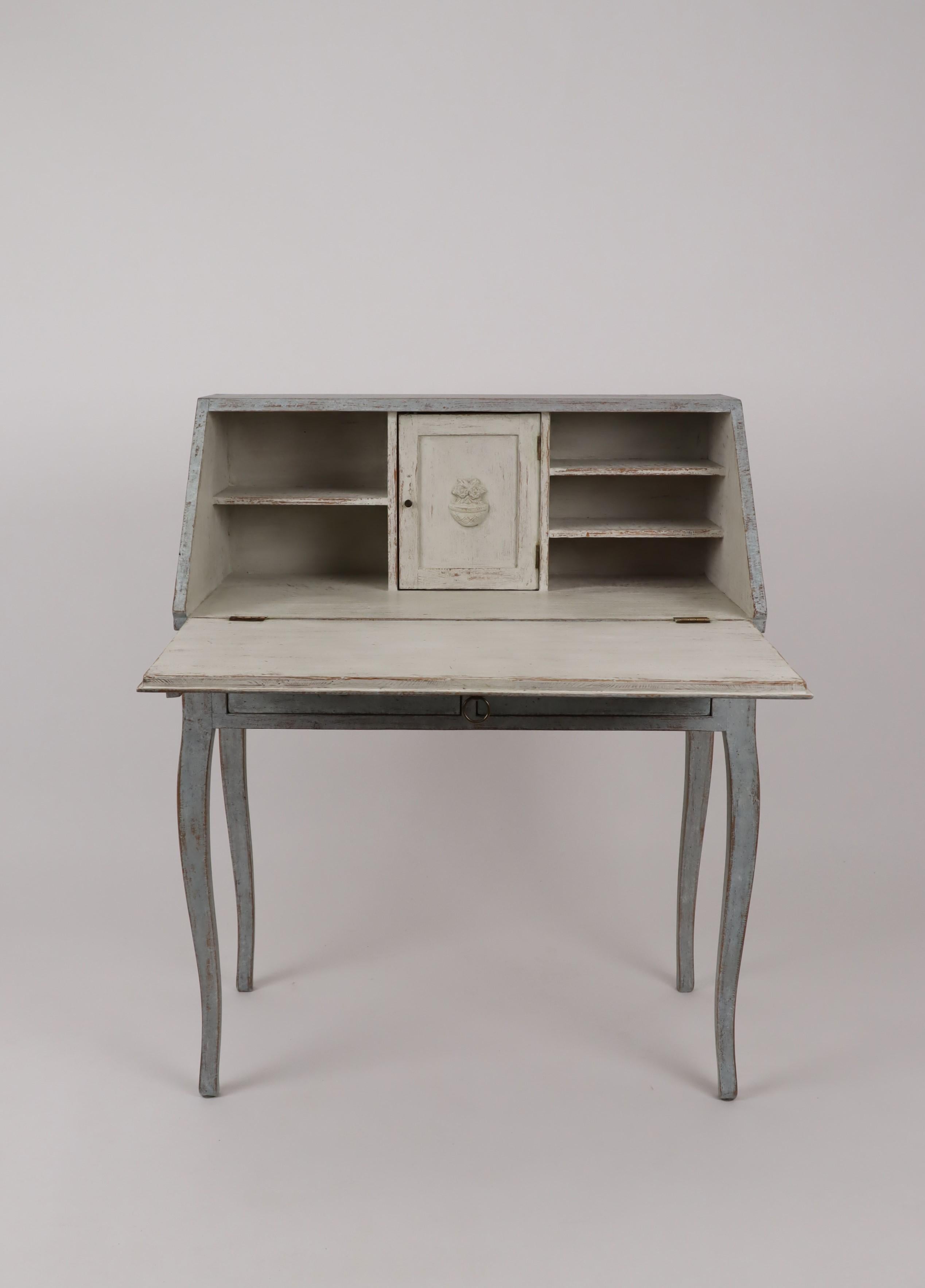 A Swedish slant-front desk from circa 1880 with blue gray painted finish, carved panels, two drawers and cabriole legs. Embrace the understated elegance of Swedish design with this exquisite slant-front desk from circa 1880. Its captivating