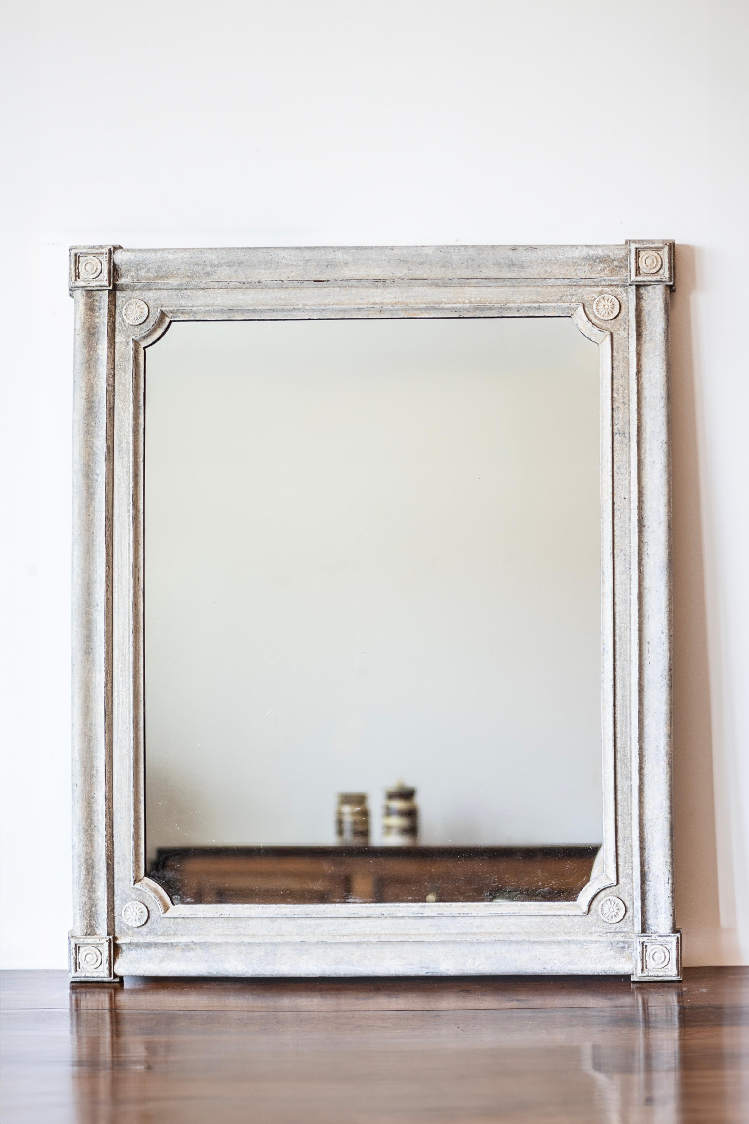 A Swedish painted wood wall mirror from circa 1880 with protruding corners and carved rosettes in medallions. This charming Swedish painted wood wall mirror, dating back to circa 1880, stands as a testament to the timeless elegance of Scandinavian