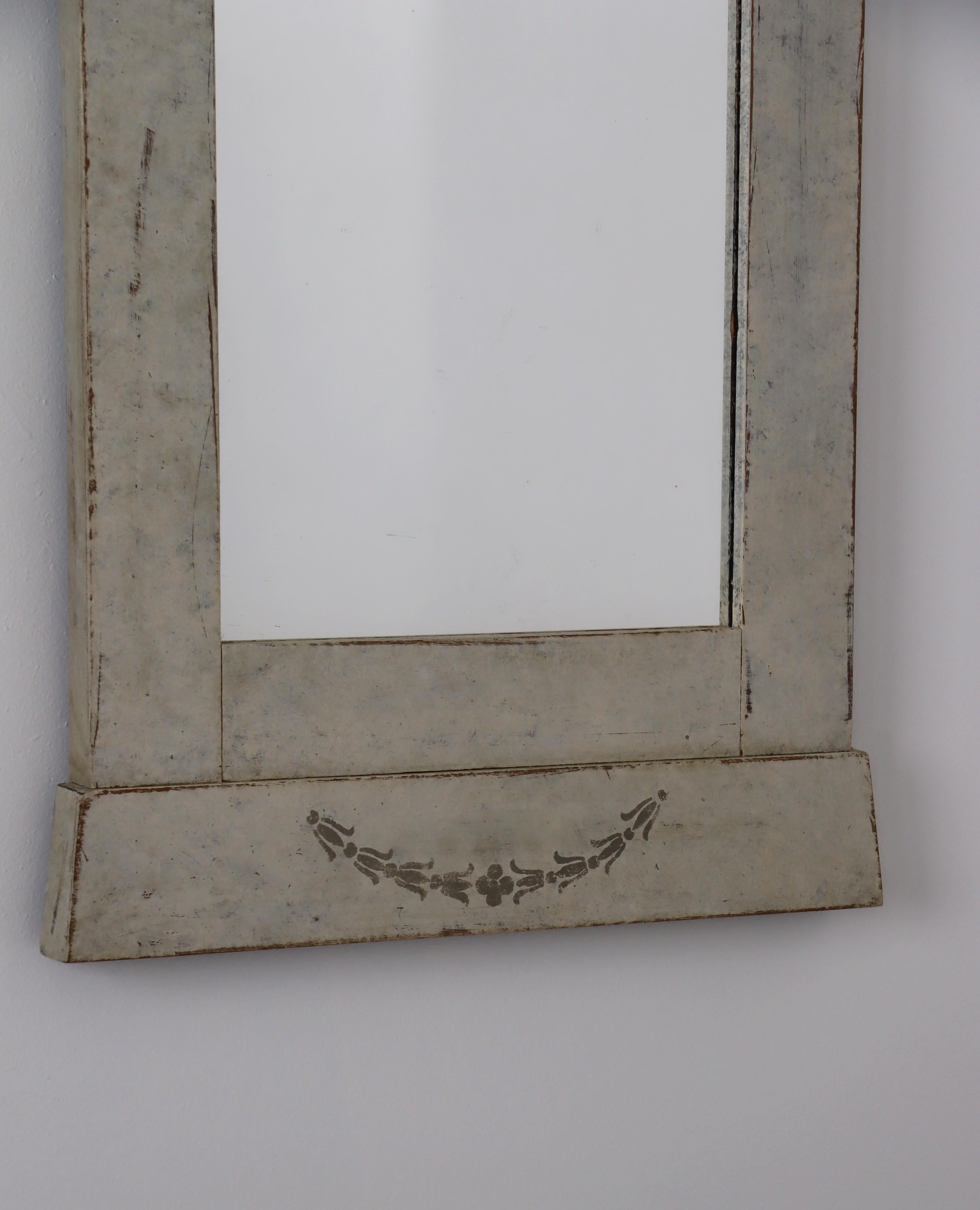 A Swedish mirror from circa 1880 with gray cream painted finish, bonnet top, carved rosette, ribbons and campanulas. This Swedish mirror, dating back to circa 1880, is a remarkable piece that gracefully combines the charm of historic craftsmanship