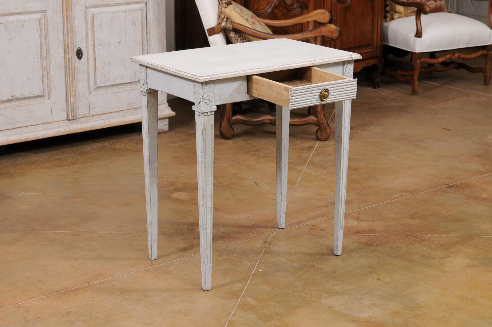 A Swedish Gustavian style console table from the late 19th century, with single fluted drawer and carved rosettes. Created in Sweden during the last quarter of the 19th century, this Gustavian style console table features a rectangular top sitting