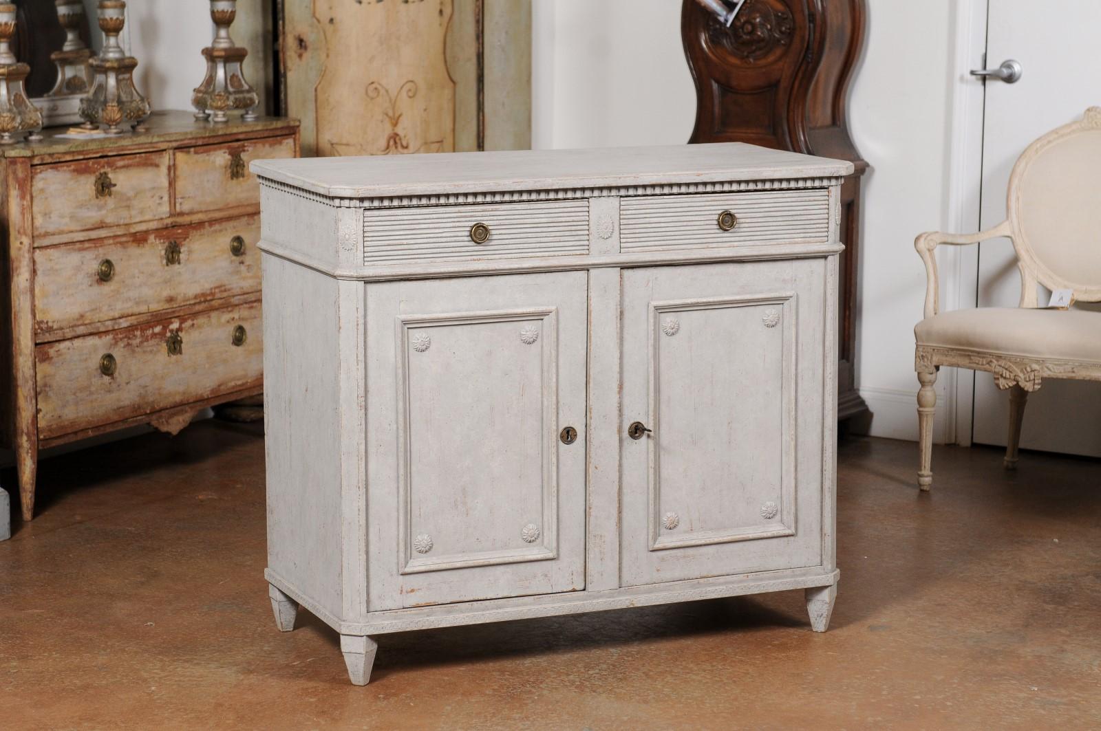 A Swedish Gustavian style painted wood sideboard from the late 19th century, with two drawers over two doors. Created in Sweden during the last quarter of the 19th century, this painted wood sideboard features a rectangular top with canted corners