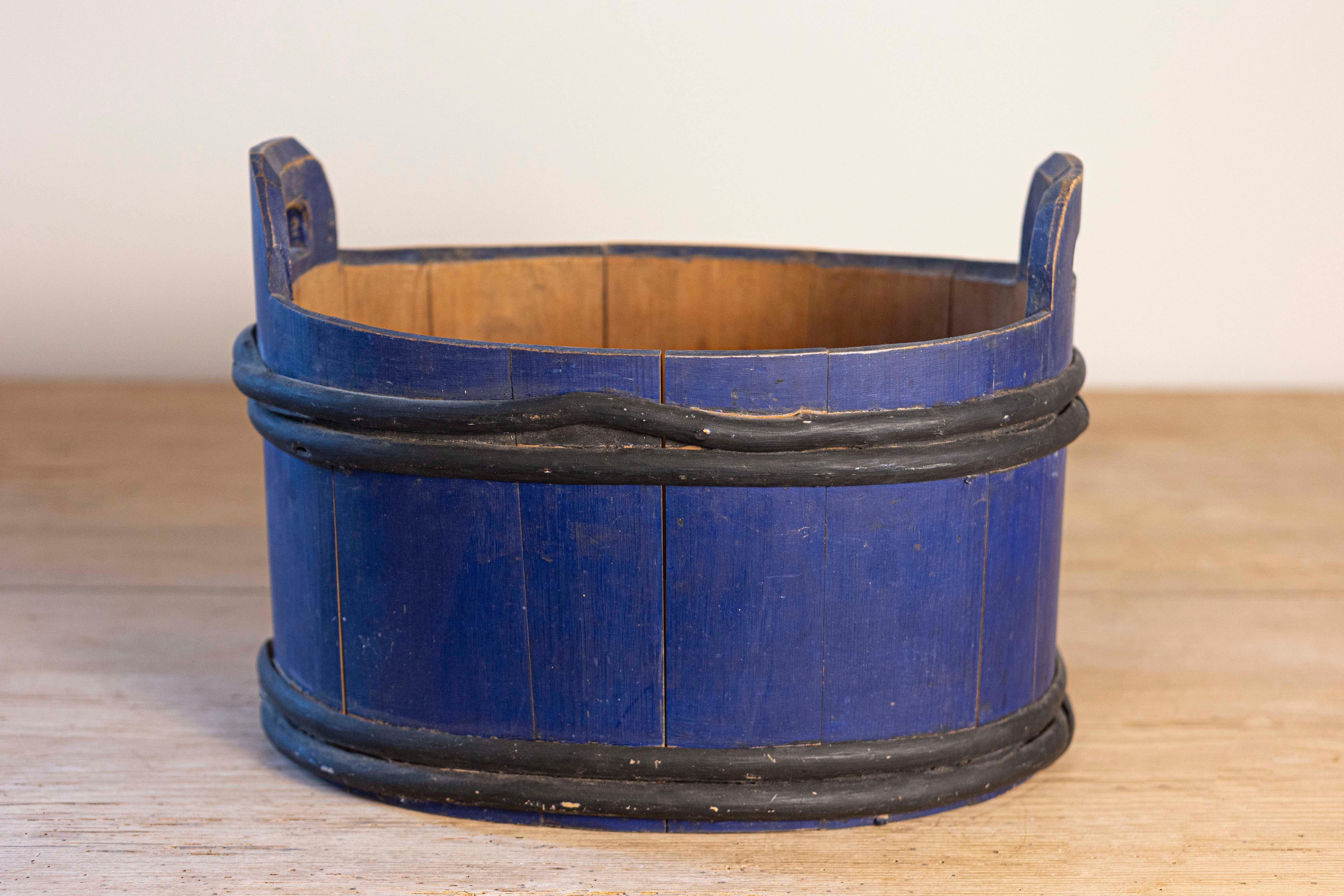Bañera de leche sueca de forma ovalada de finales del siglo XIX con pintura azul y detalles negros. Creada en Suecia durante el último cuarto del siglo XIX, esta bañera de leche nos llama la atención por su carácter rústico y su pintura azul