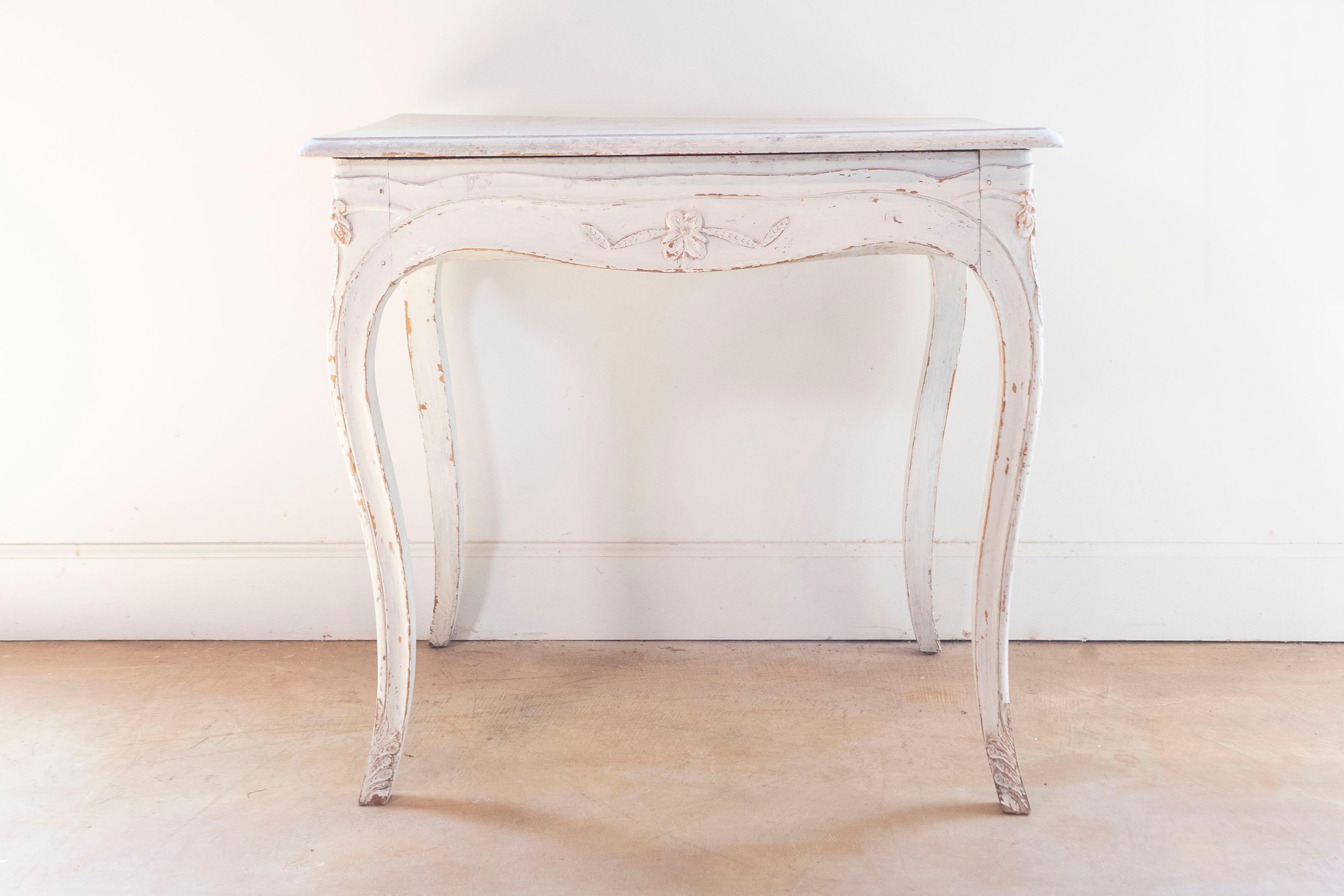 Table d'appoint suédoise peinte de la fin du XIXe siècle, avec tablier sculpté et pieds en cabriole. Cette table d'appoint suédoise présente un plateau rectangulaire aux bords biseautés, surmontant un tablier magnifiquement sculpté sur tous les