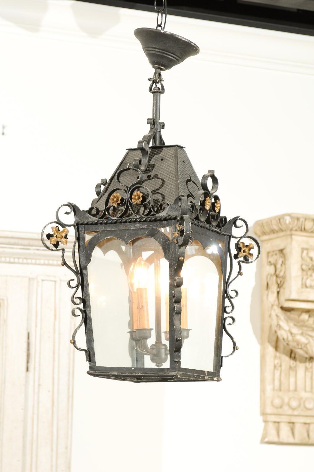 A Swedish black iron three-light lantern from the late 19th century, with gilt floral accents. Born in Sweden during the last decade of the 19th century, this charming lantern features a black iron structure adorned with delicate gilt flowers