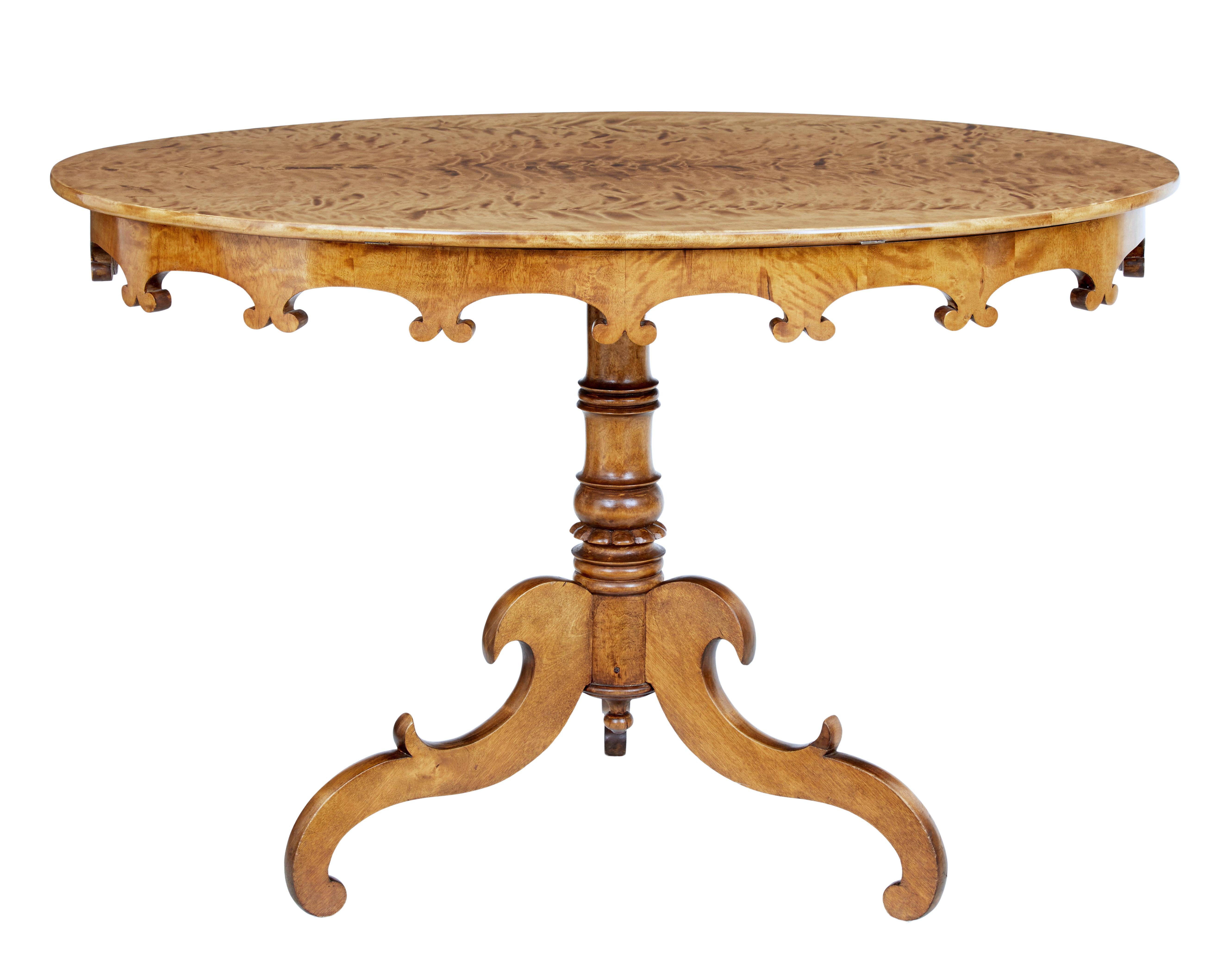 A Swedish burr birch wood occasional table circa 1890 with oval top, carved apron, turned pedestal and tripod base made of delicately carved legs. Experience the charm of 19th century Swedish craftsmanship with this beautifully made burr birch wood