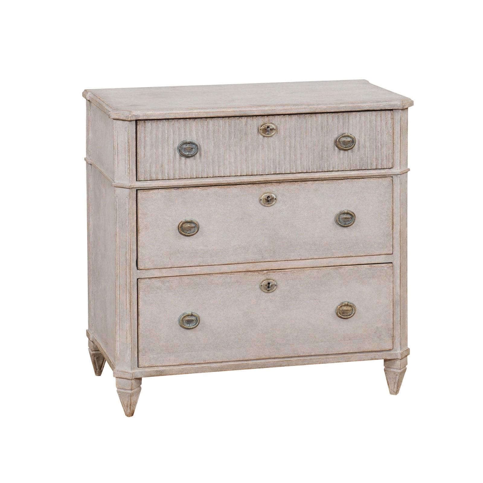 A Swedish Gustavian style gray painted chest from circa 1890 with three drawers, reeded accentuation and tapered feet. This Swedish Gustavian style chest, originating from the late 19th century, is a masterpiece of understated elegance and refined