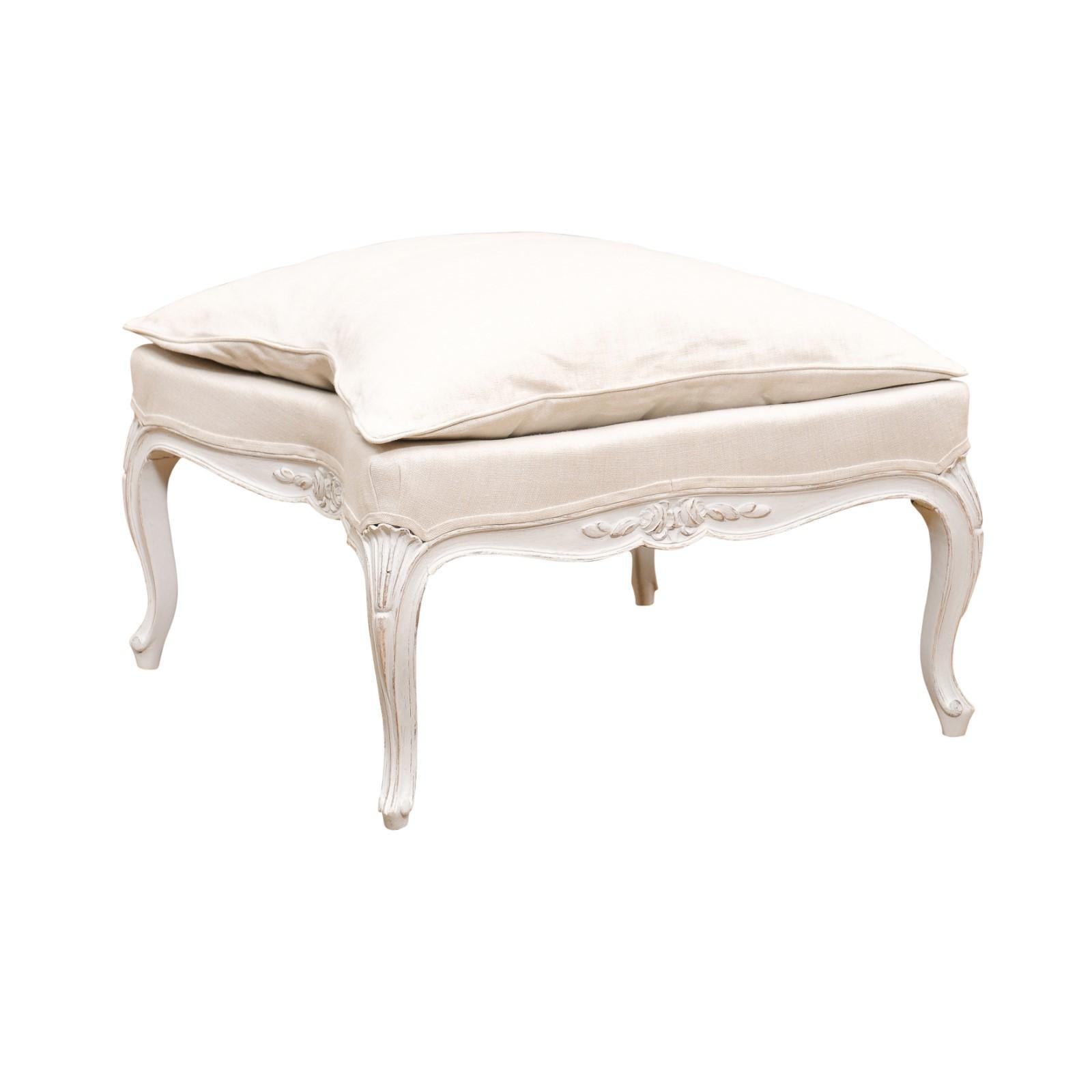 A Swedish Rococo Revival painted wooden stool from the late 19th century, with cabriole legs, carved motifs and new upholstery. Created in Sweden during the last decade of the 19th century, this painted stool features a square seat topped with a
