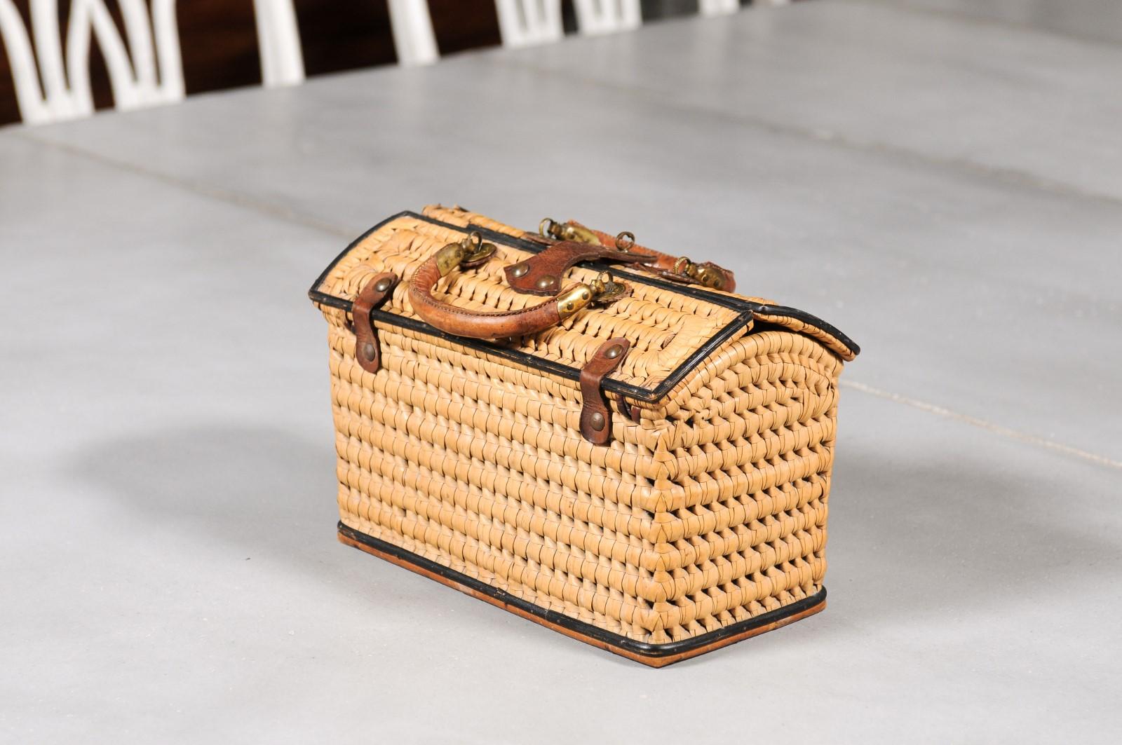 A Swedish rectangular shaped wicker basket from the late 19th century, with leather straps, slanted lid and small handles. Charming us with its rustic appearance, this Swedish basket features a slanted lid opening thanks to a single leather strap to