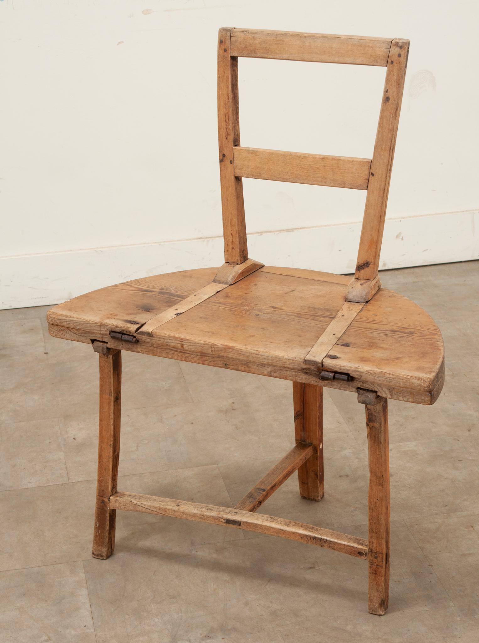 A pine Swedish chair-table from the 1700’s. This functional antique is a chair that converts into a table by use of hand forged iron hinges that allow the chair’s back to fold down and form the table’s top and legs. Cleaned and polished with a paste