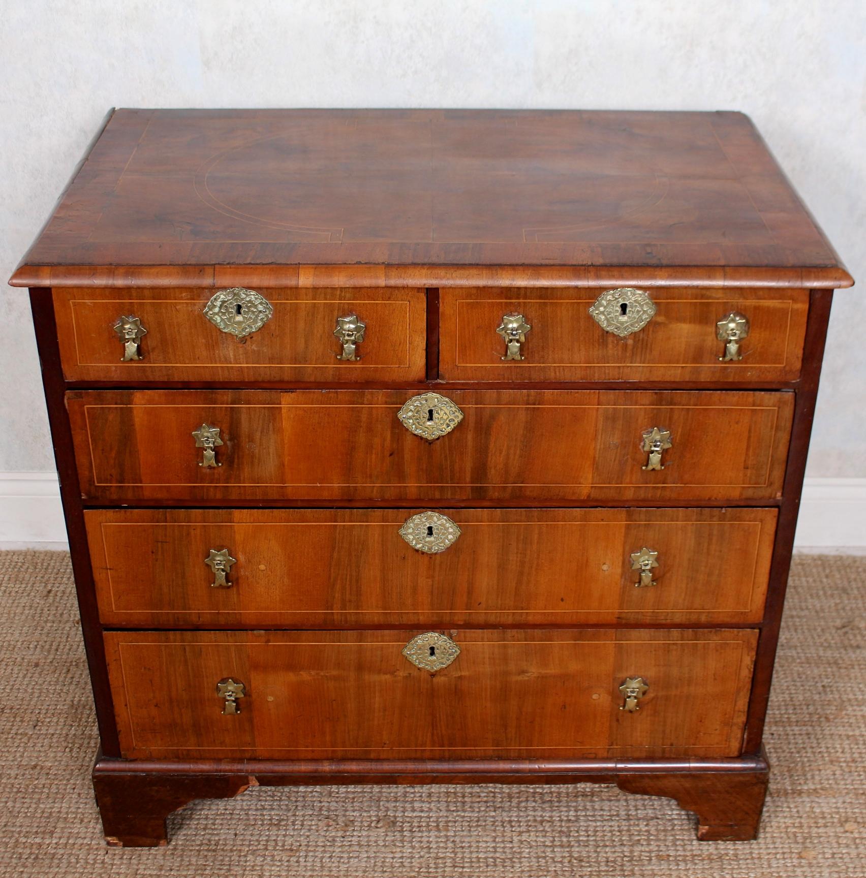 An 18th century Swedish inlaid walnut chest of drawers.

The rectangular moulded edged top inlaid with geometric designs above an arrangement of two short over three long graduated drawers oak lined interiors and mounted with attractive brass