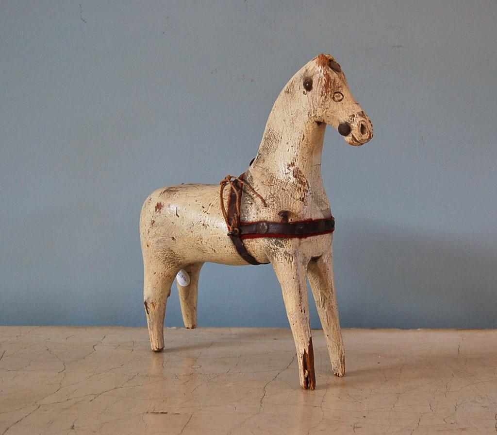 A Swedish 18th century dala horse, origin: Sweden, circa 1750. Hand-carved horse, from one piece of wood, including charming carved details such as the eyes and nose; original 18th century paint and remnants of original leather and red fabric saddle