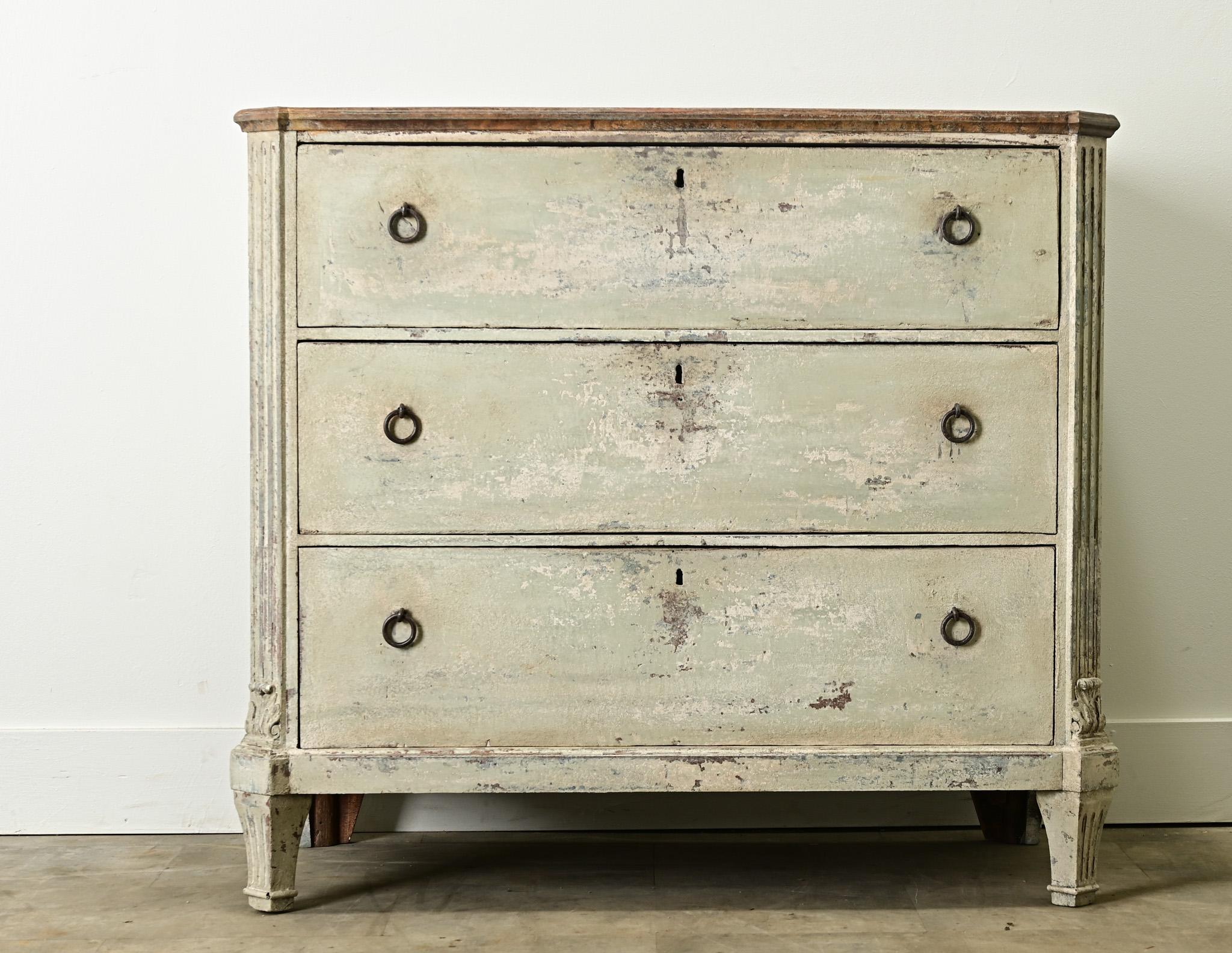A Swedish Gustavian chest of drawers from the late 1700’s with its original paint finish. The top is painted a charcoal color, mimicking Belgium bluestone. The cabinet has a layered paint finish with three easy-to-use drawers with iron ring pulls.