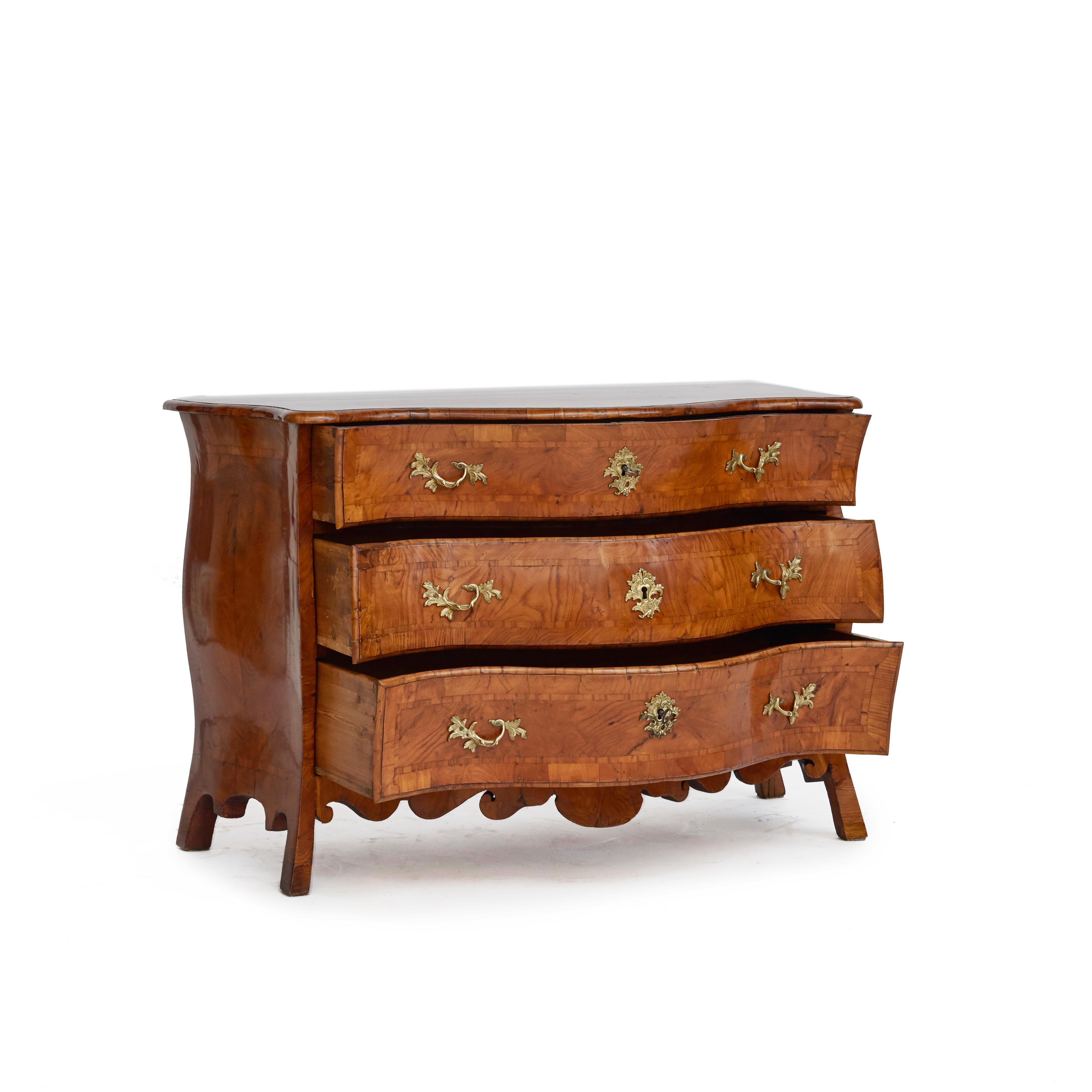 A Swedish rococo serpentine bombe commode or chest of drawers veneered in elm with a stunning grain.
Features three large drawers with original bronze fittings.
The beautiful rich color and patina has been enhanced with a sophisticated French