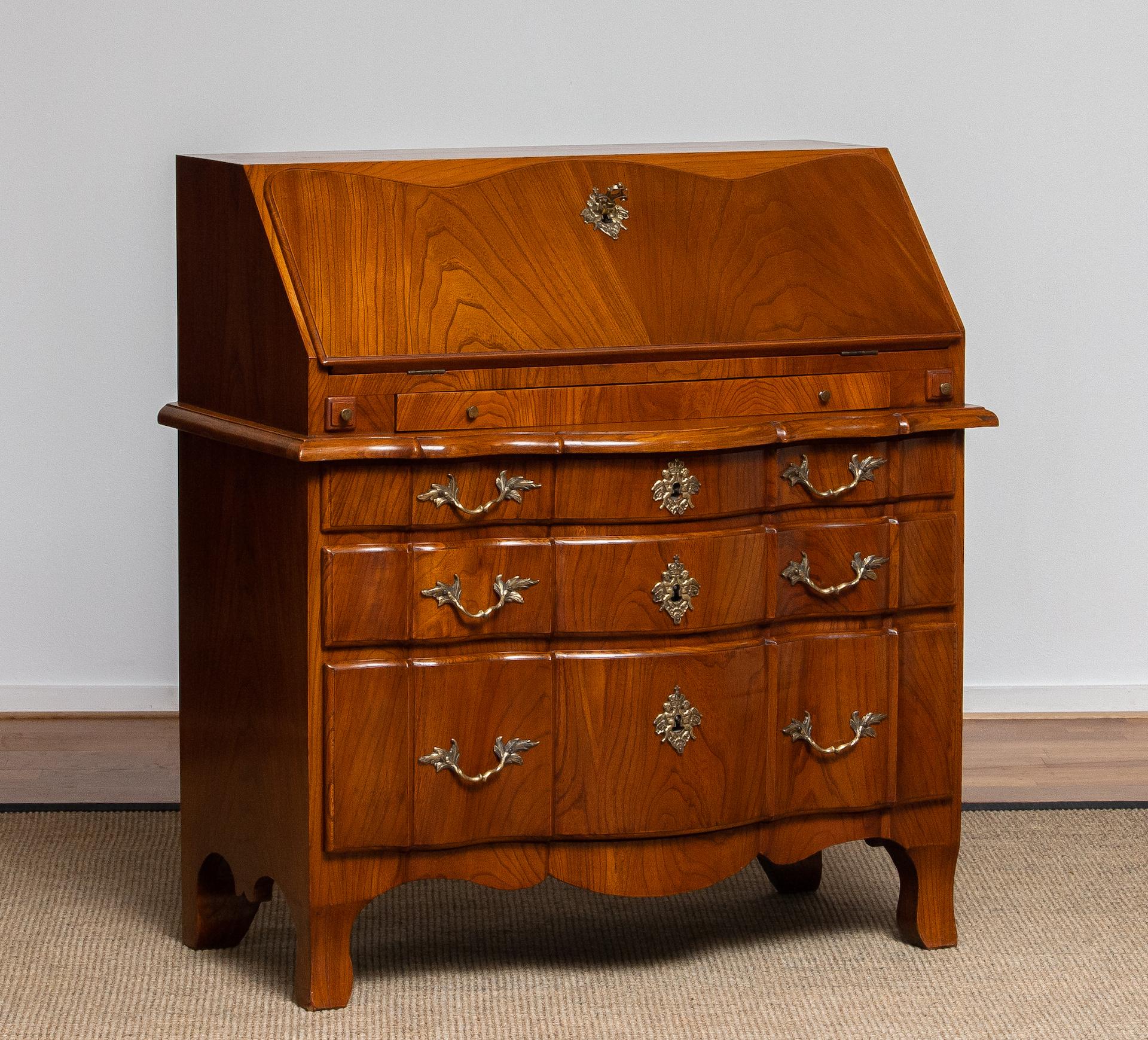 Elegant 18th-century Swedish secretary desk, crafted in richly grained wood with a warm patina. The piece features a slant-front writing surface that opens to reveal a fitted interior with drawers and compartments. Below are three serpentine-front