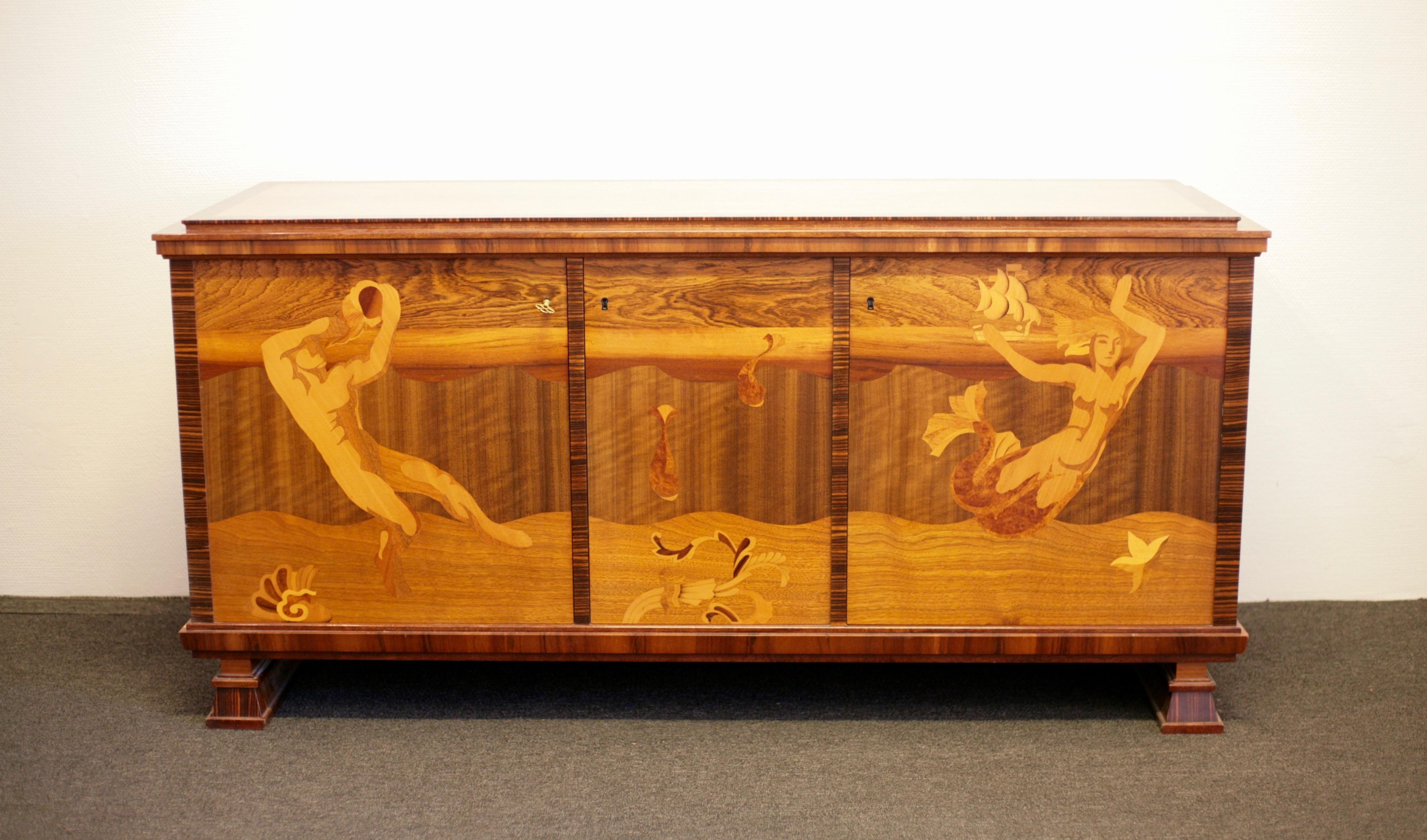 Exquisite Swedish Art Deco sideboard in the manner of Carl Malmsten. Rich with intarsia depicting Poseidon, a mermaid, two fish, seashells and a ship. Macassar veneer covering sides and back which is highly unusual. Makes it possible to place the