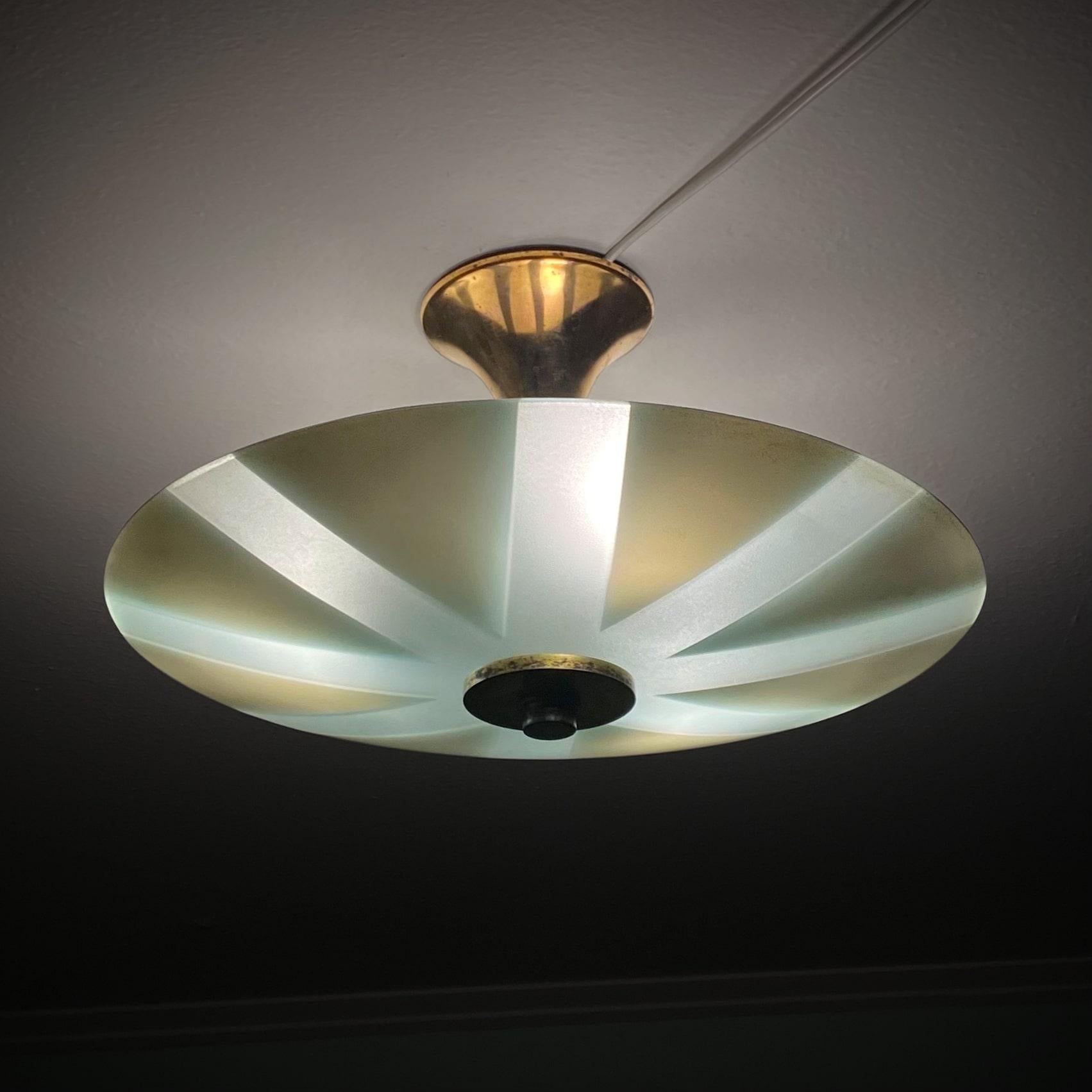 Swedish 1930s ceiling fixture made from glass and brass. Large circular glass bowl with white triangles mounted on a brass frame with a large bell-shaped canopy. Three E27 lamp sockets are mounted just above the glass shade.