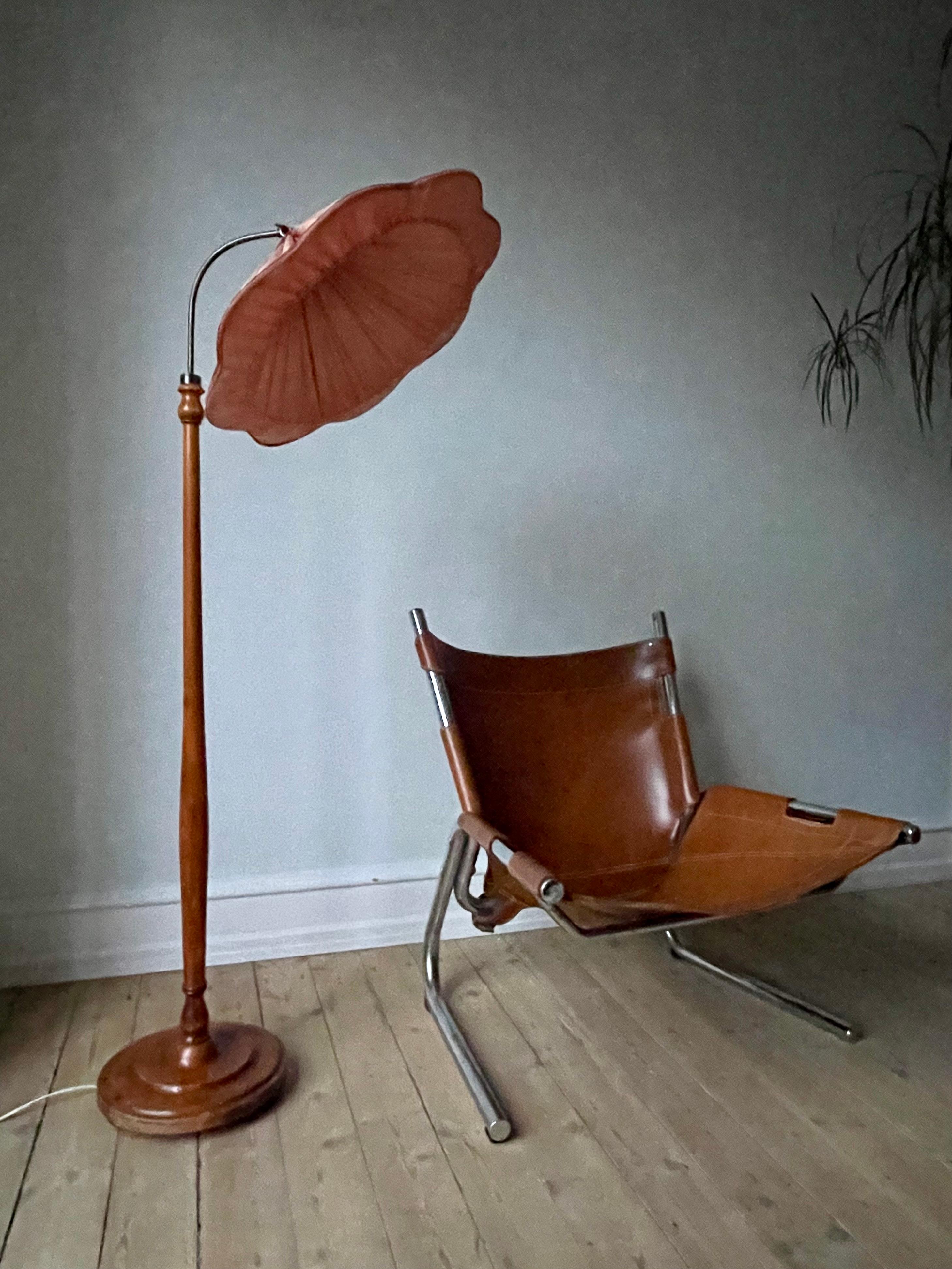 1920s-30s Swedish Grace Art Nouveau floor lamp in the style of Josef Frank, Svenskt Tenn. Original large rose colored fabric lamp shade in a organic flower-like shape 53 cm (21 in) wide. Lacquered wood stem and base with soft relief decorations.