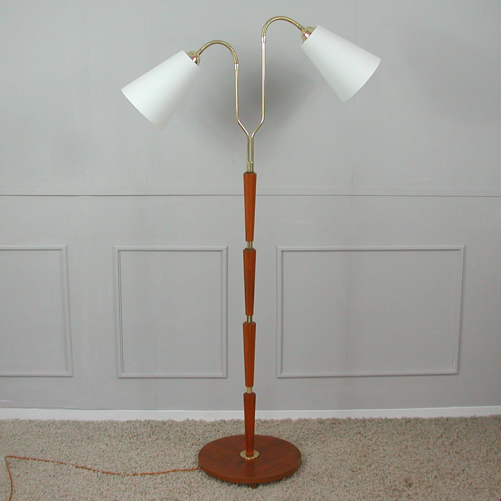 This unusual organic floor lamp was designed and manufactured in Sweden in the 1940s. It features a teak lamp base, brass hardware and two adjustable gooseneck lamp arms. Shades are handmade in off white silk (new). 

The floor lamp can be