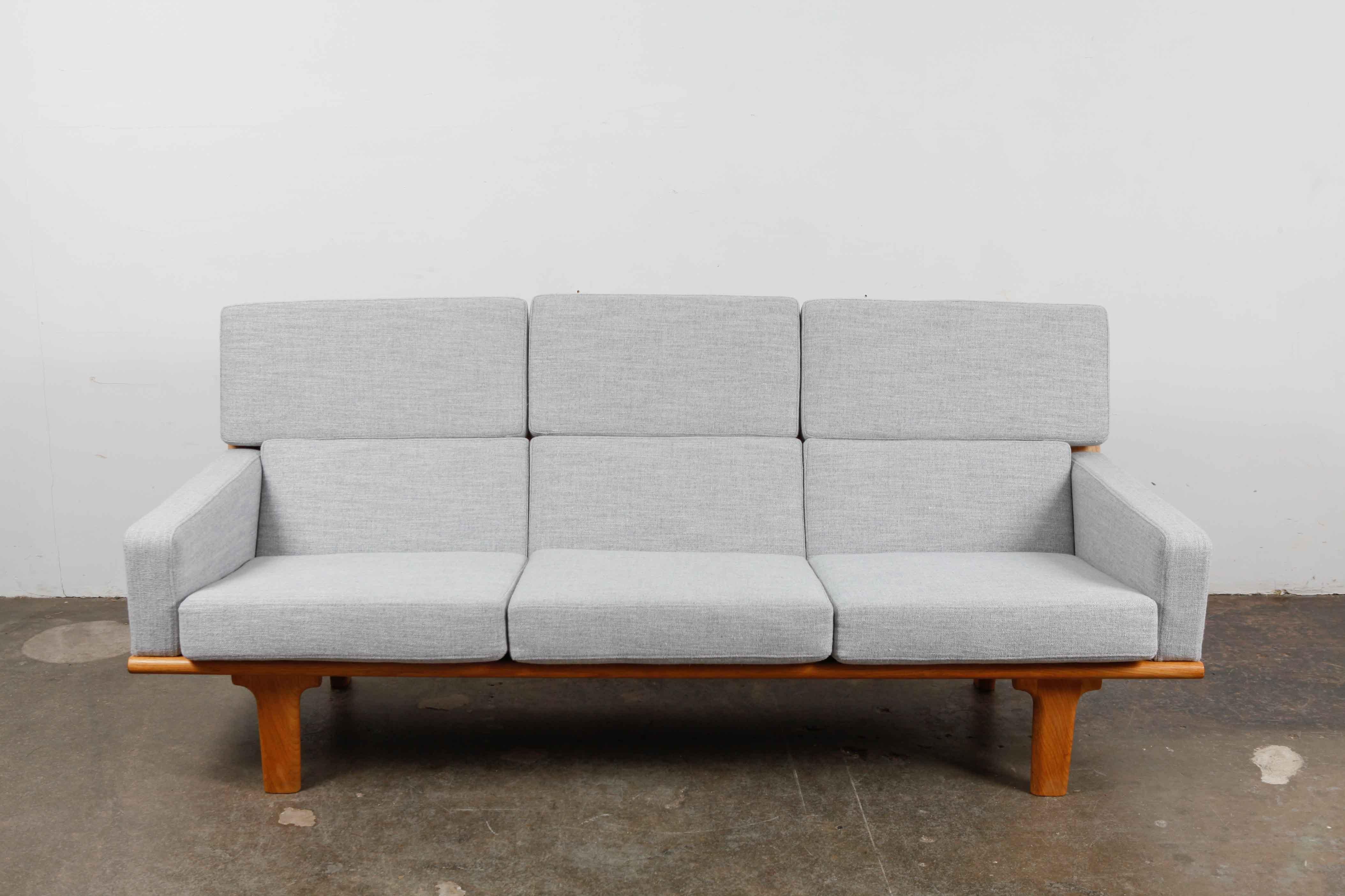 Swedish solid oak framed sofa with high back, newly upholstered in a light blue/gray woven linen fabric with new foam and the frame is completely refinished in a matte natural wax finish. Beautifully exposed back wood frame.