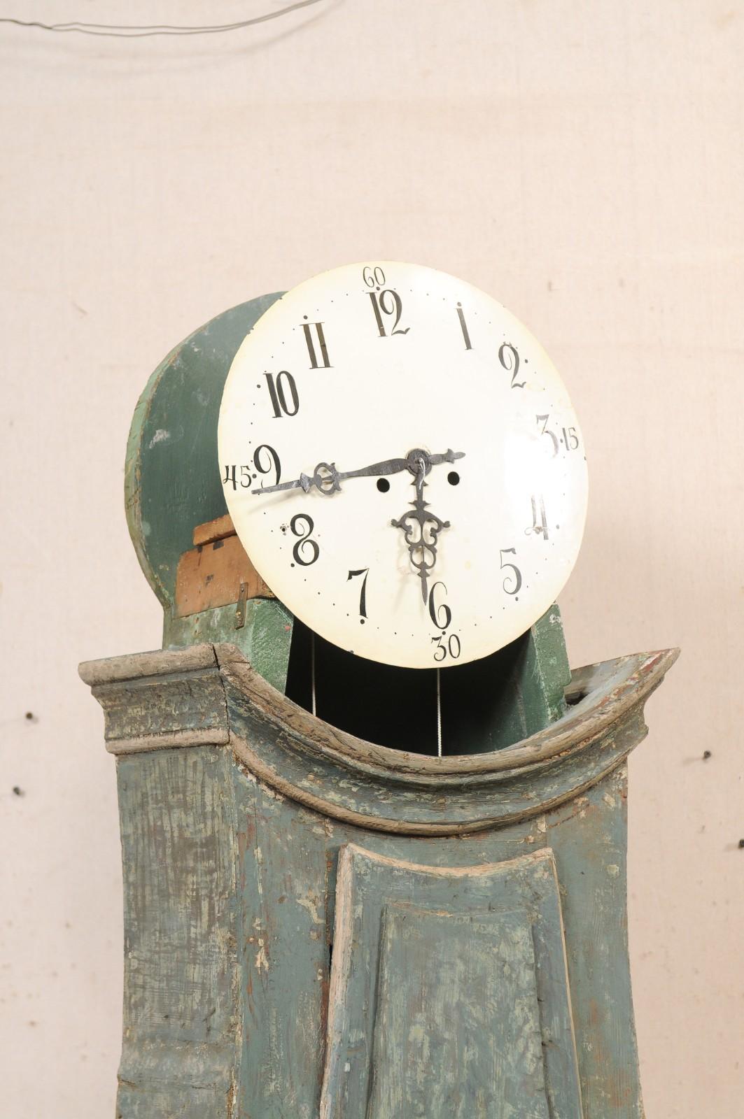 Un orologio a pendolo in legno dipinto di Wood del XIX secolo. Questo antico orologio da pavimento alto proveniente dalla Svezia ha un cofano rialzato a calotta quadrata che incorona la sua testa a forma rotonda, che ospita il quadrante e il