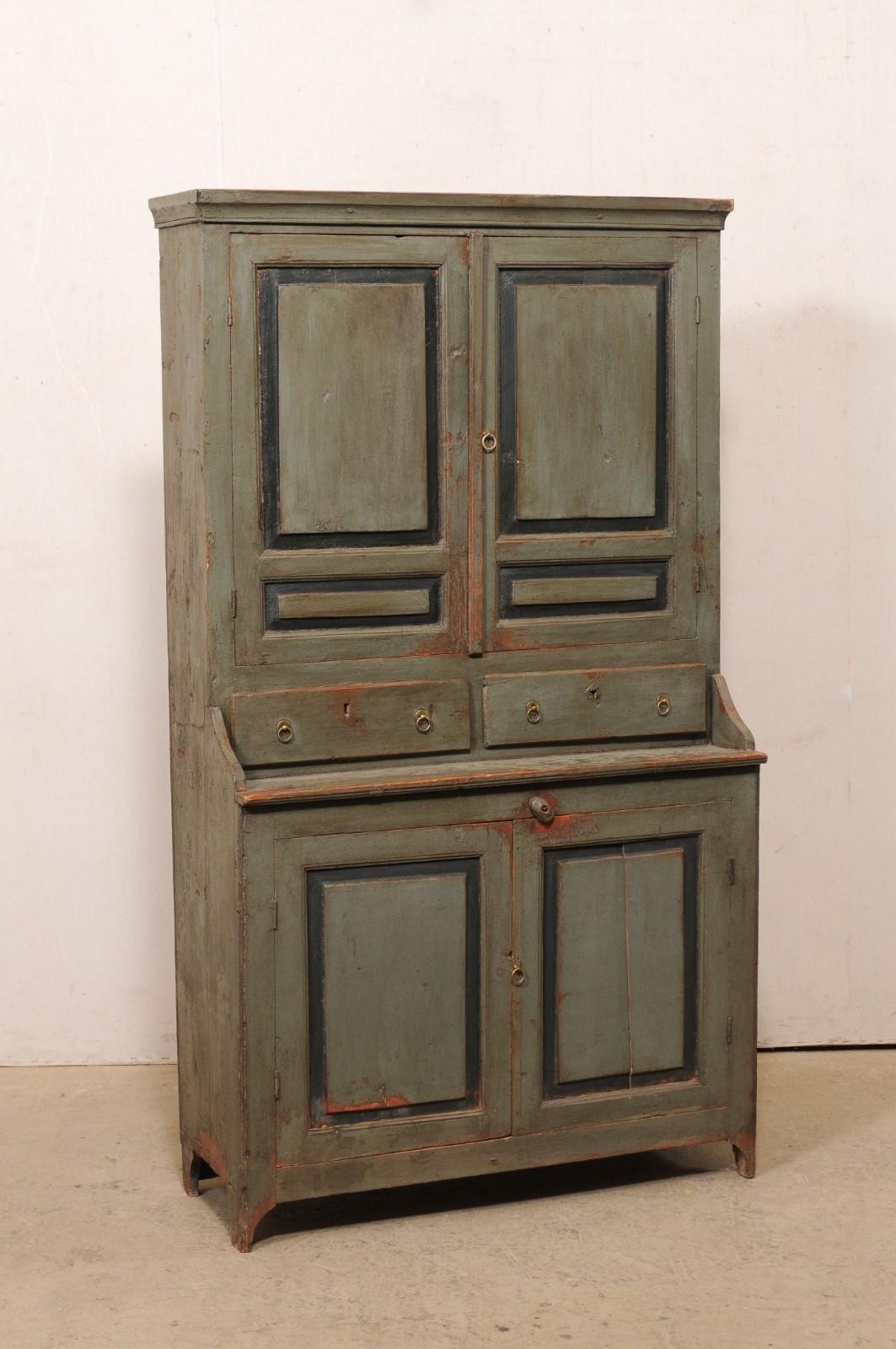 A Swedish painted wood cupboard cabinet in green from the 19th century. This tall antique storage cabinet from Sweden offers plentiful storage opportunities! The more slender, upper section, which sits recessed back over the lower section, is fitted