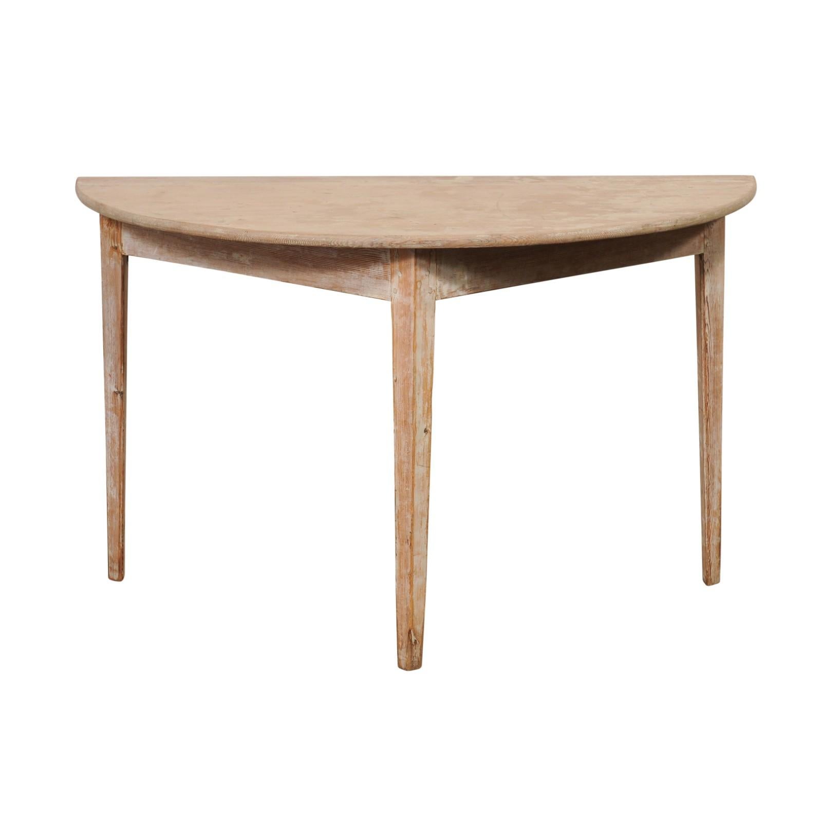 A single Swedish wooden demi-lune console table from the 19th century. This antique table from Sweden features a semi-circular, or half moon top, over a triangular-shaped apron. The skirt is clean and plain, and the piece is raised upon three