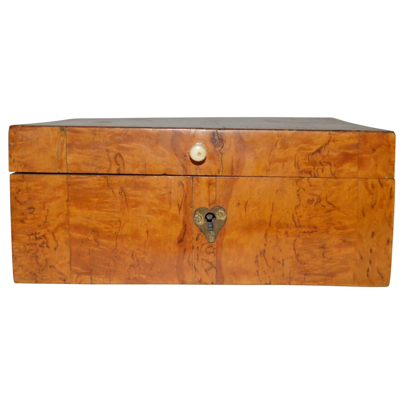 Swedish 19th century birchwood veneer jewelry box.

The box has a heart of brass for keyhole and knob hardware of antler.