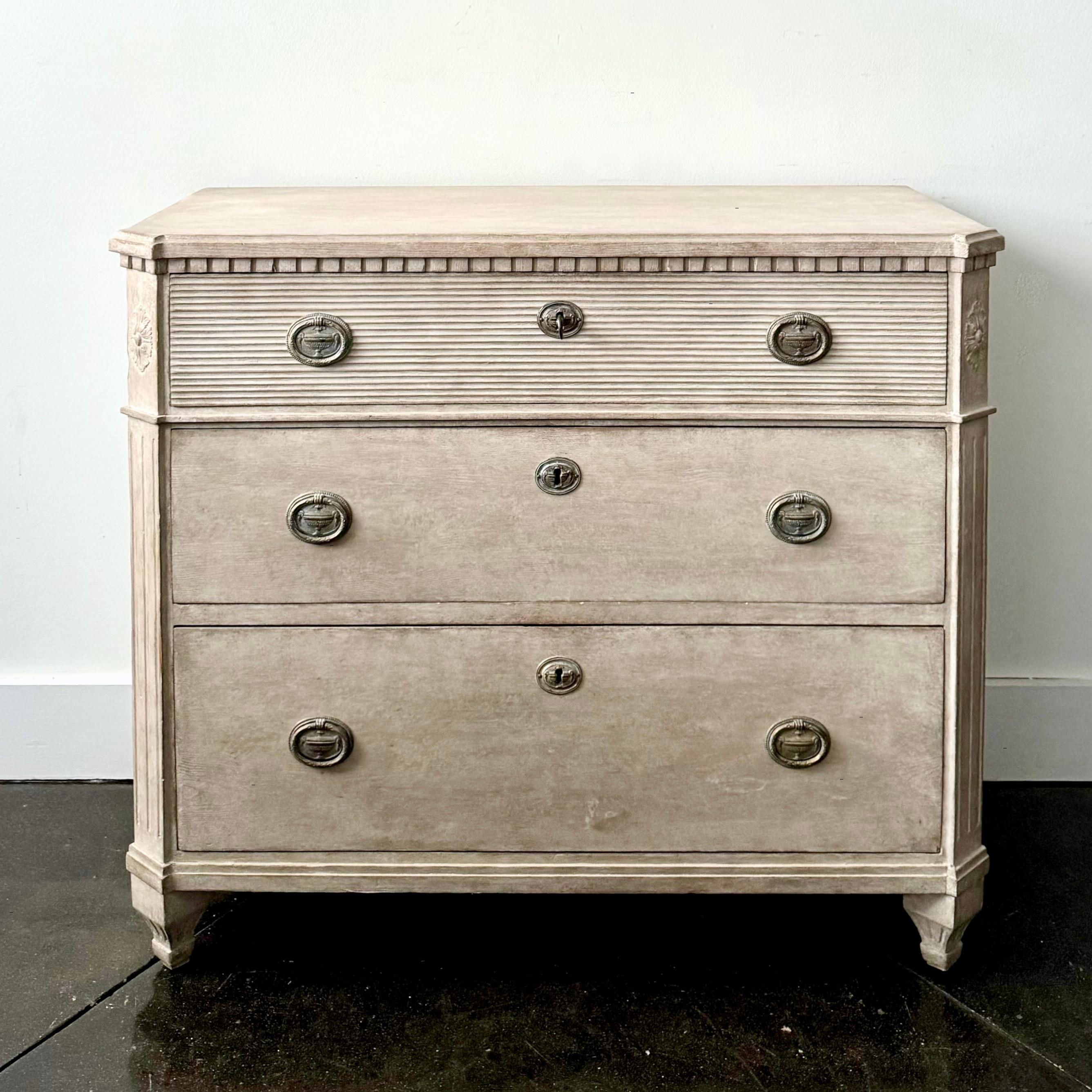  A Swedish Gustavian style chest of drawers with fluting on front of the upper drawer. Shaped top with dental trim under, reeded canted corners and classical feet. 
Very classical Swedish piece with original hardwares.
Sweden, circa 1860. 
Here are
