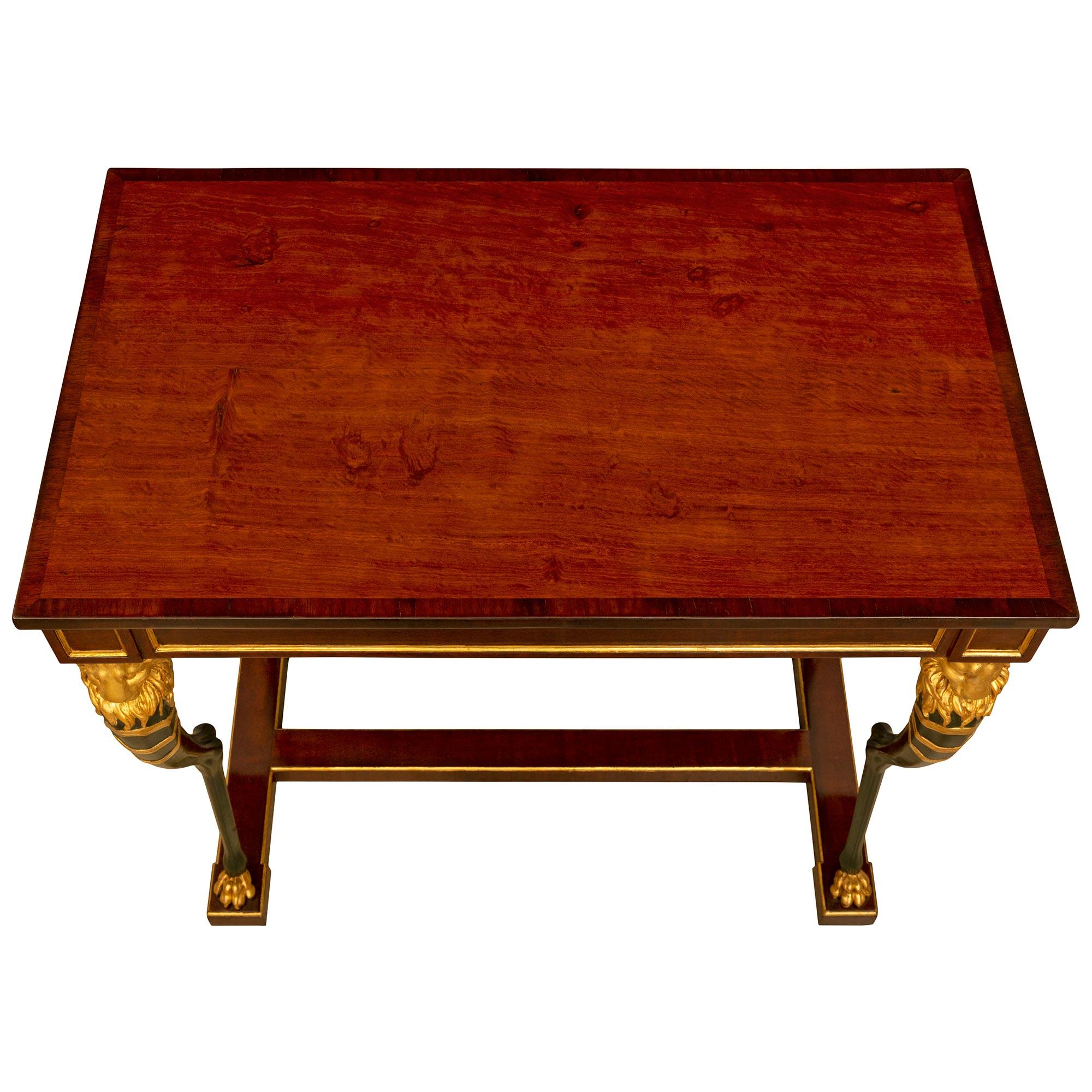 A remarkable and most elegant Swedish 19th century Empire st. Mahogany, polychrome and giltwood center table. The rectangular table is raised by an elegant H shaped bottom mahogany stretcher with a fine mottled giltwood border with striking and