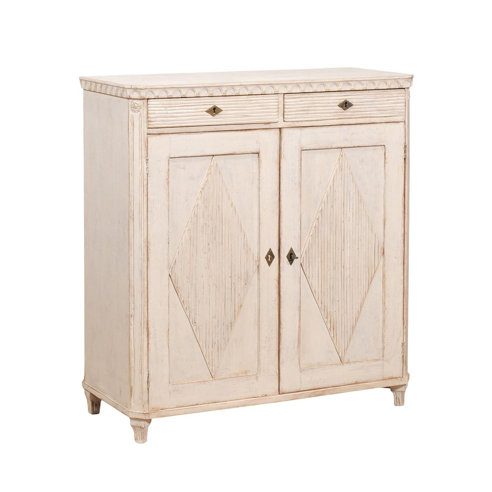 A Swedish Gustavian style sideboard from the 19th century with off white / light gray painted finish, carved diamond motifs and tapered feet. This exquisite Swedish Gustavian style sideboard from the 19th century embodies the timeless elegance and