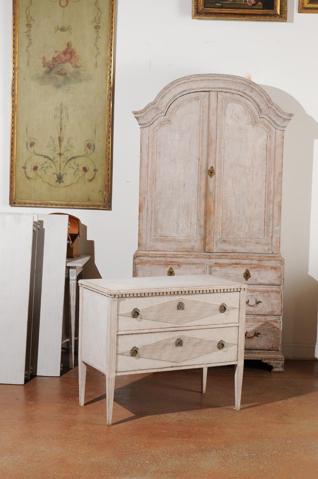 A Swedish Gustavian style painted wood chest of drawers from the 19th century, with reeded diamond motifs and dentil molding. Created in Sweden during the 19th century, this Gustavian style chest features a rectangular top with protruding corners,