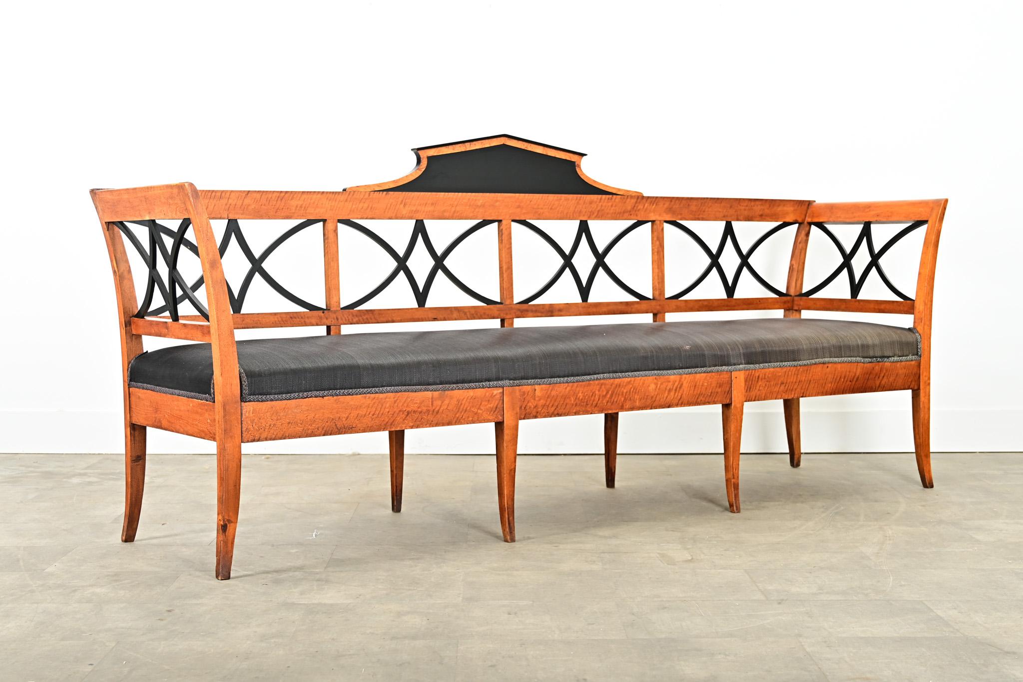 This wonderful 19th century Swedish maple settee features classic Biedermeier design elements adapted to Scandinavian tastes for lightness and simplicity, using only the finest quality materials and techniques. The wide bench seat–wrapped in woven